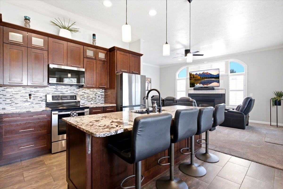 Updated kitchen features granite counters, 10' island, composite granite single-basin sink, stainless steel appliances, tall cabinetry, pull-outs, soft-close drawers and cabinets, pantry, &  broom closet