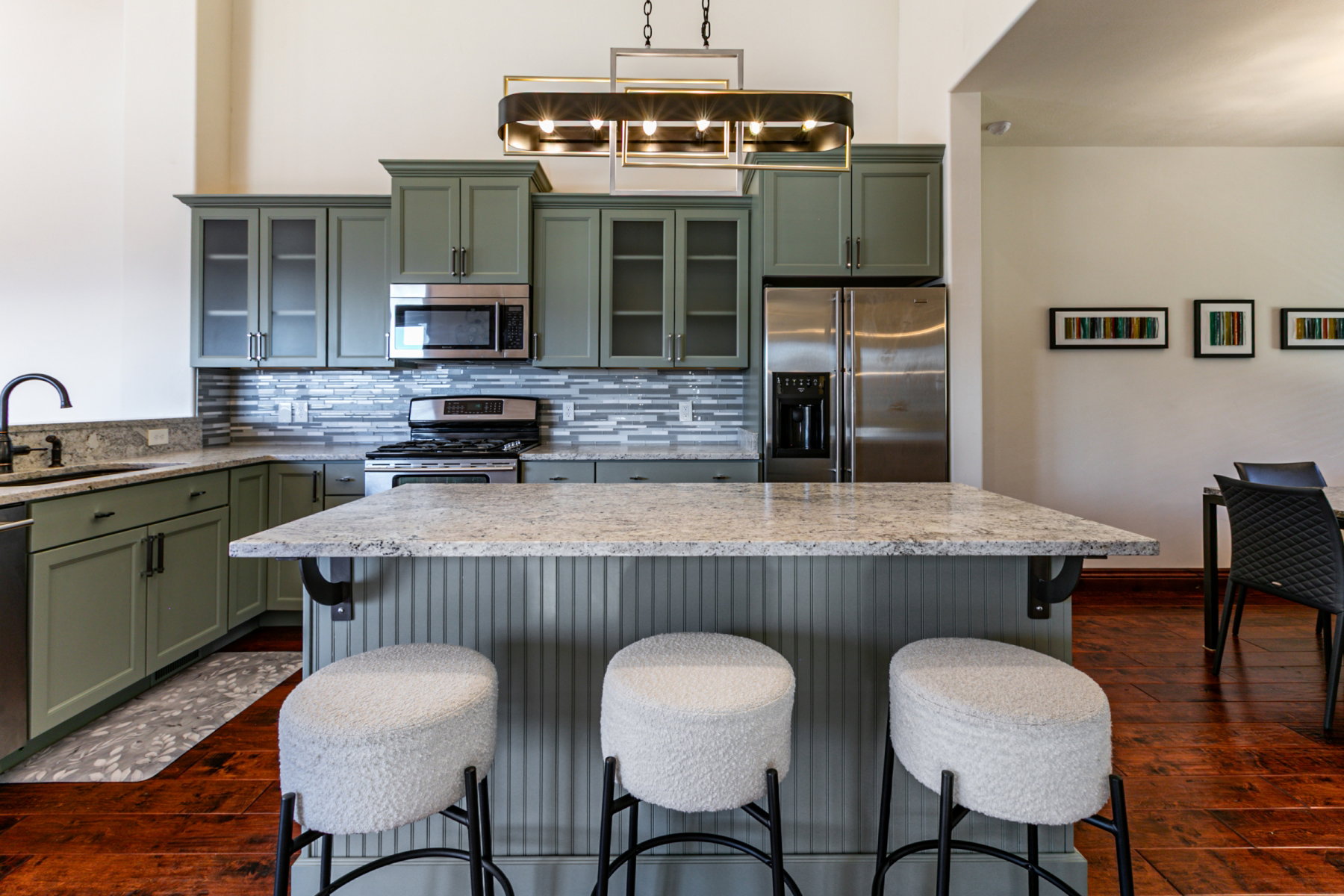 Kitchen featuring a central island with a light-toned countertop, beadboard paneling, and pendant lighting