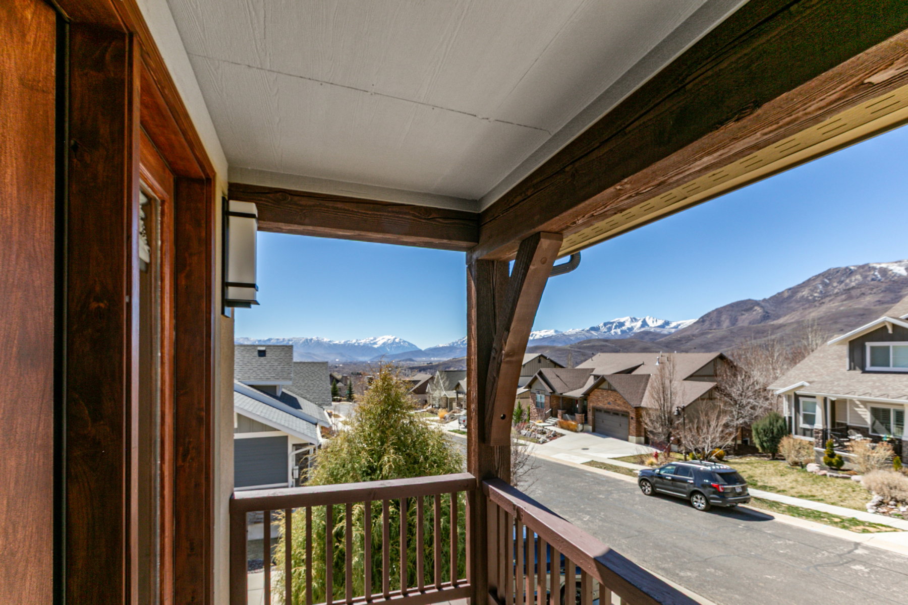 Balcony with wood-finish railing and exposed wood beams