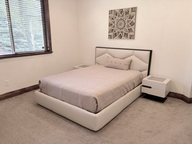 Carpeted room featuring a window with wood blinds, white walls, and dark wood baseboards