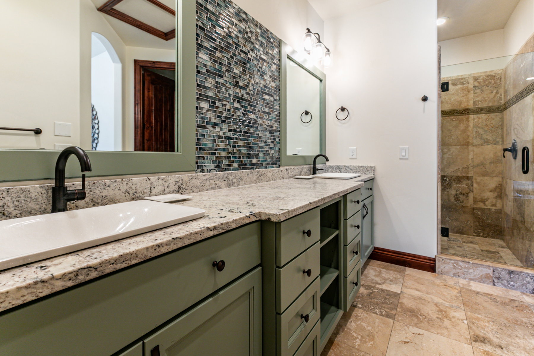 Dual vanity featuring granite countertops, undermount sinks, and matte black fixtures
