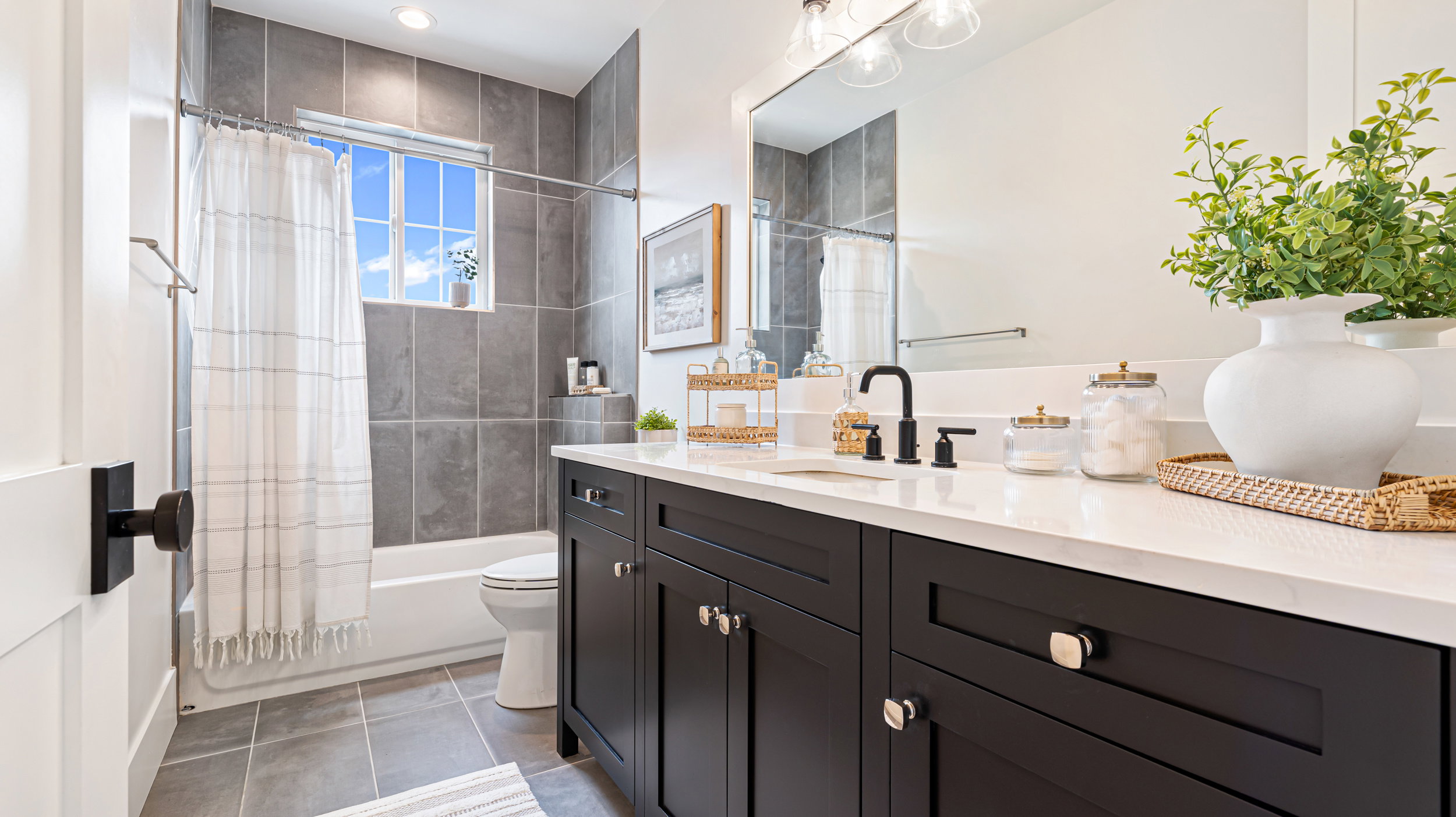 Bathroom featuring a dark wood-finish vanity with a light-colored countertop, undermount sink, and matte black faucet