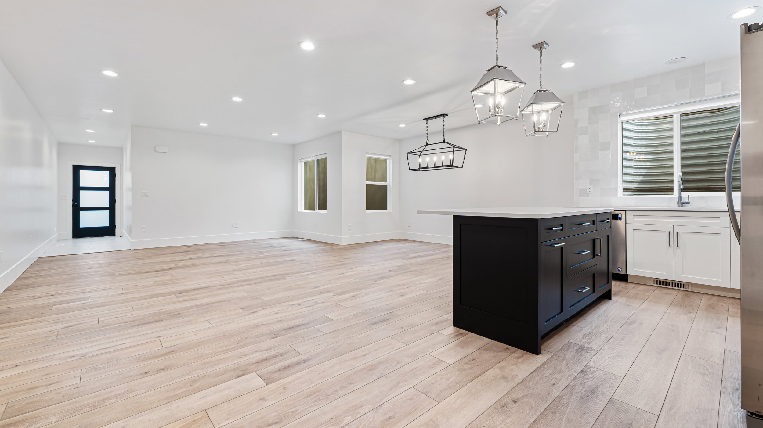 Expansive open-concept living space with wood-finish flooring