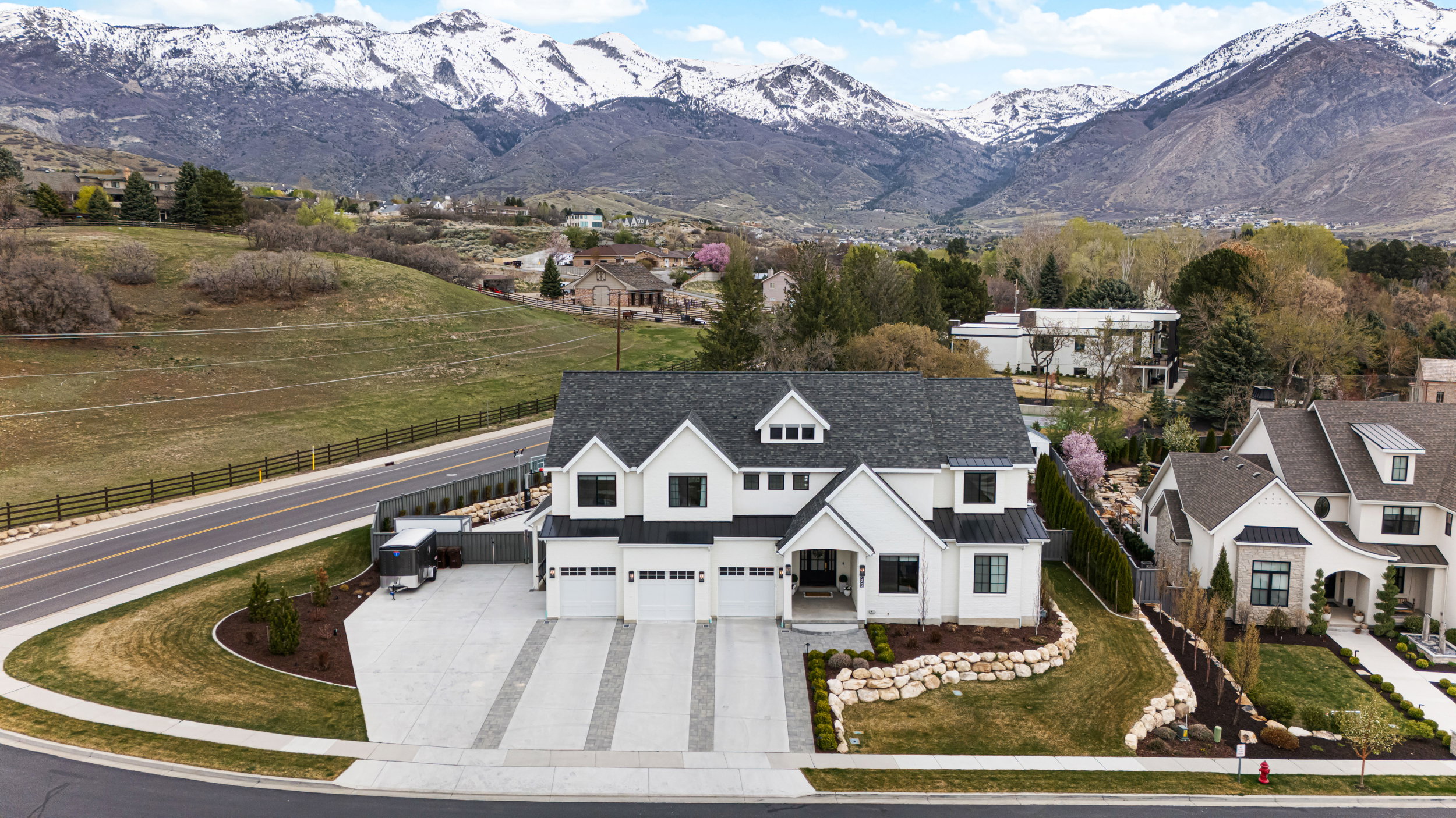 Modern farmhouse exterior with crisp white siding, dark-framed windows, and a multi-car garage