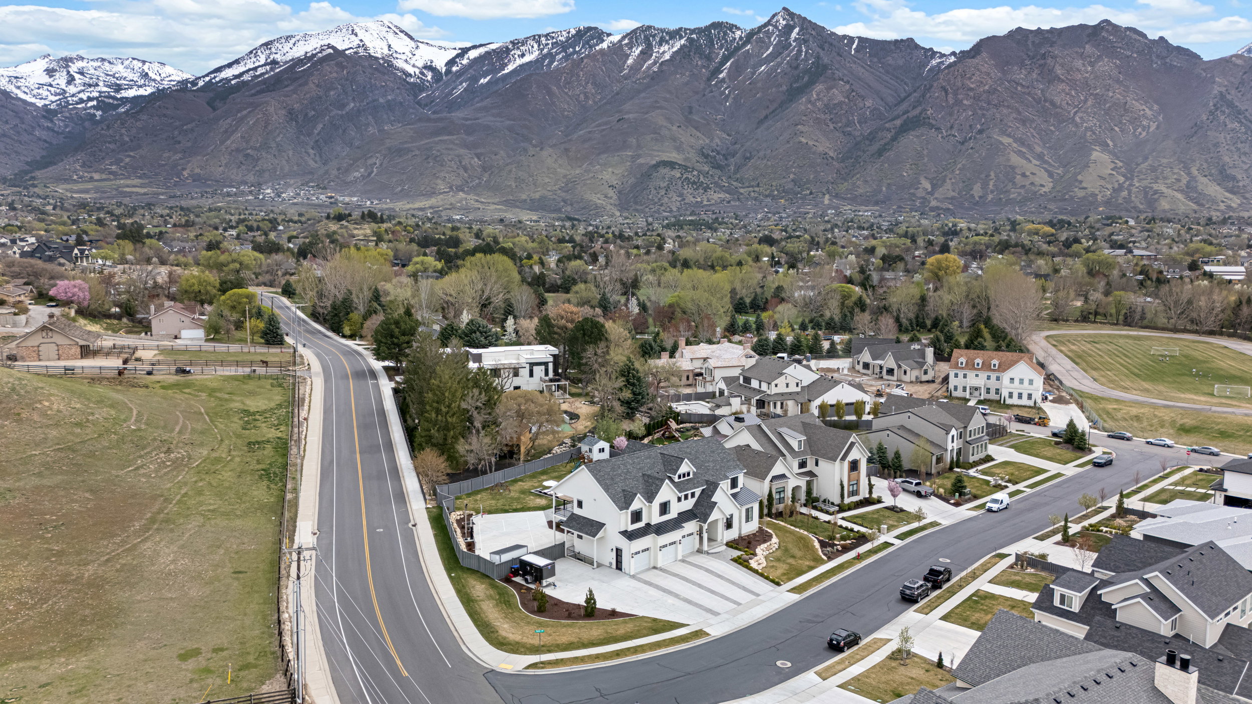 Contemporary single-family residences featuring varied architectural designs, manicured landscaping, and multi-car garages