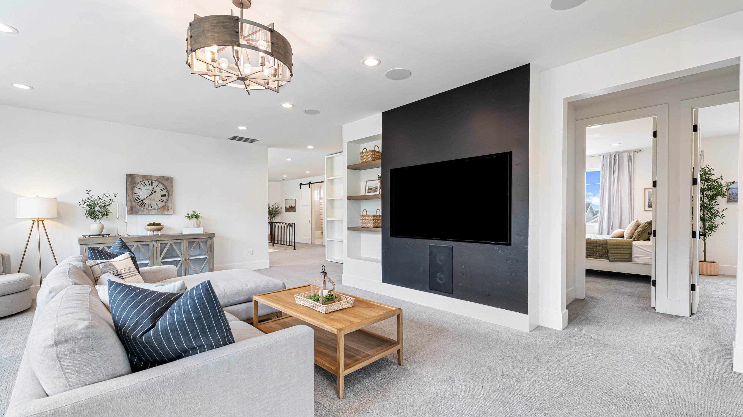 Spacious living area featuring light gray carpeting, recessed lighting, and a contemporary ceiling fixture