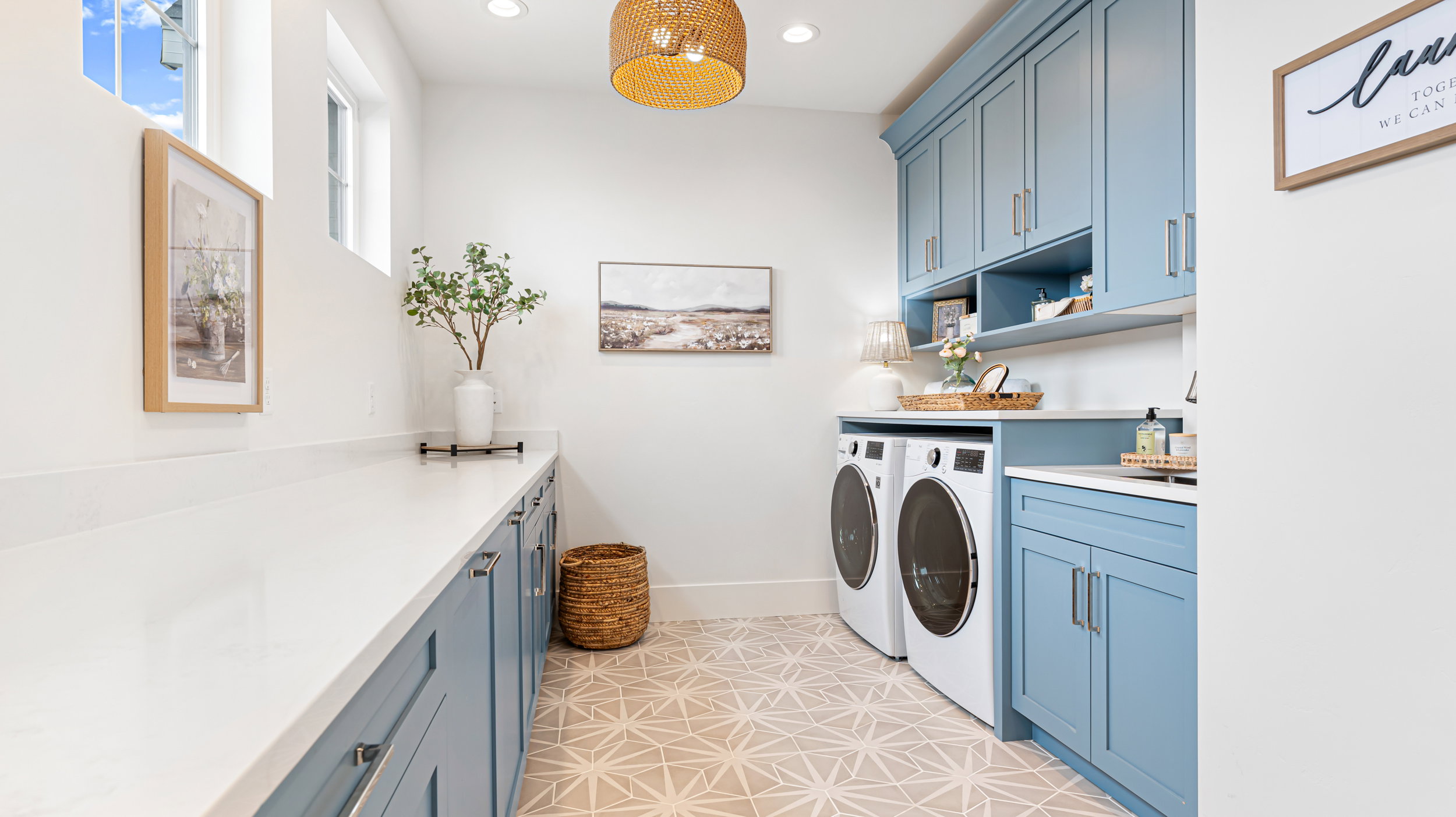 Utility room with custom blue cabinetry, light-toned countertops, and geometric pattern floor tiling