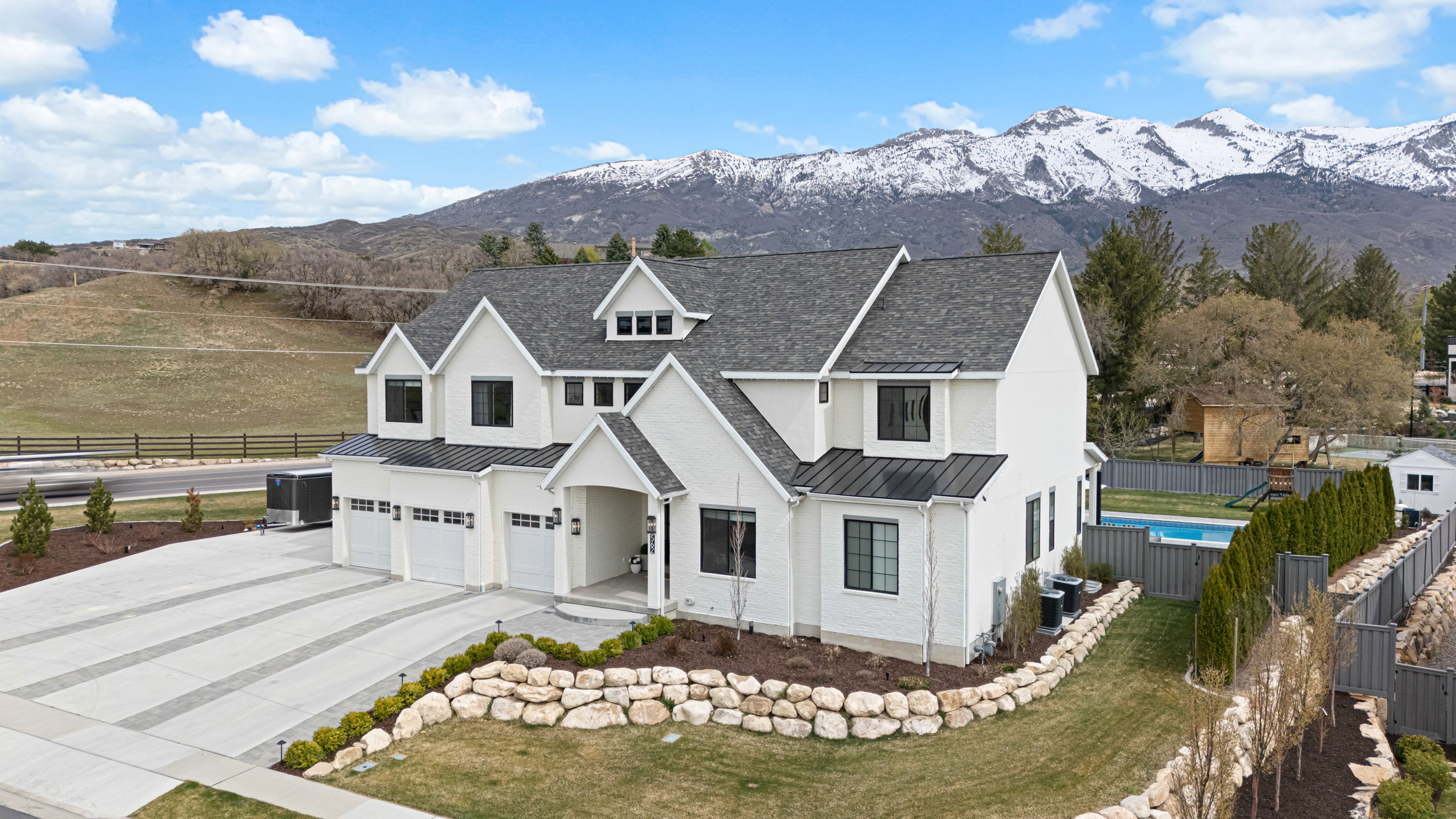 Expansive modern farmhouse with a multi-gabled roofline and a three-car garage