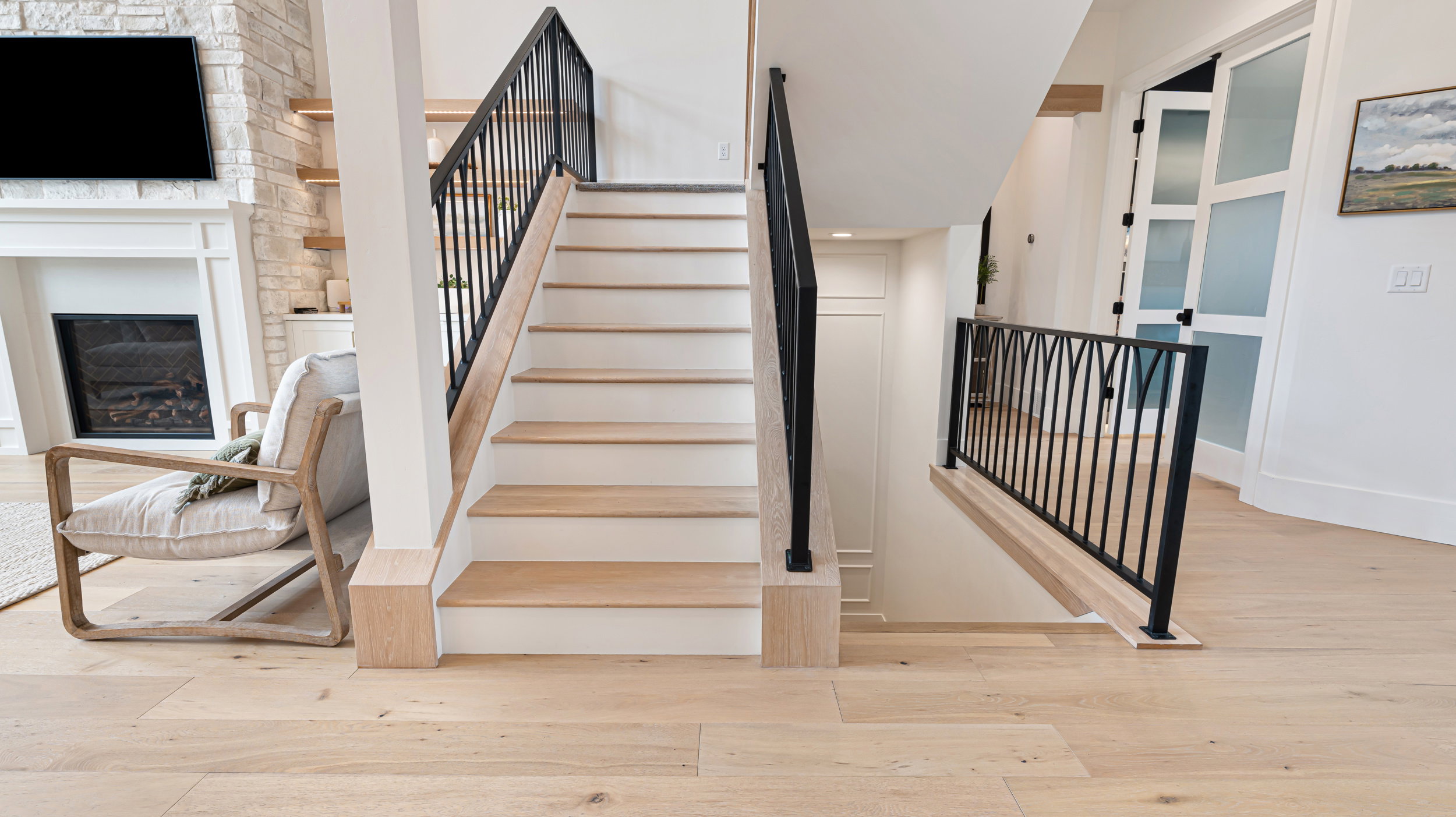 Light wood-finish flooring featuring an open staircase with white risers and wood treads