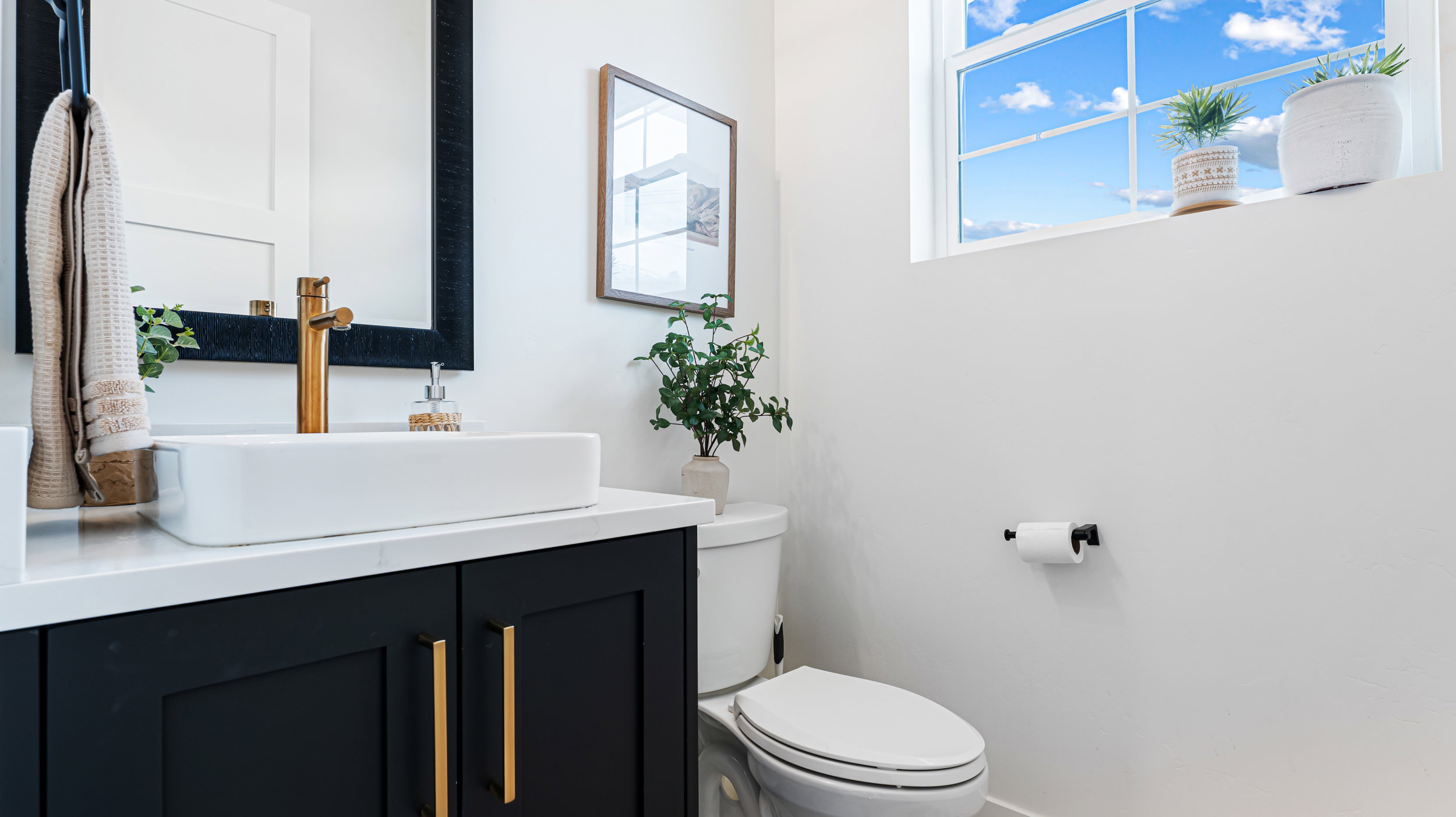 Vanity with a rectangular vessel sink, gold-finish faucet, and white countertop