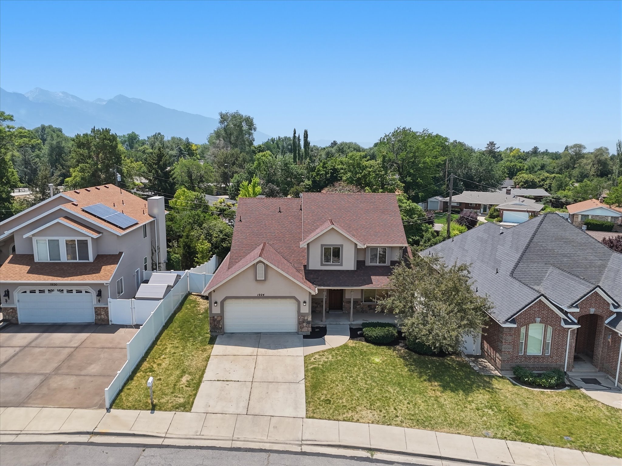 Two-story residence with a brown shingle roof, attached two-car garage, and a covered front porch