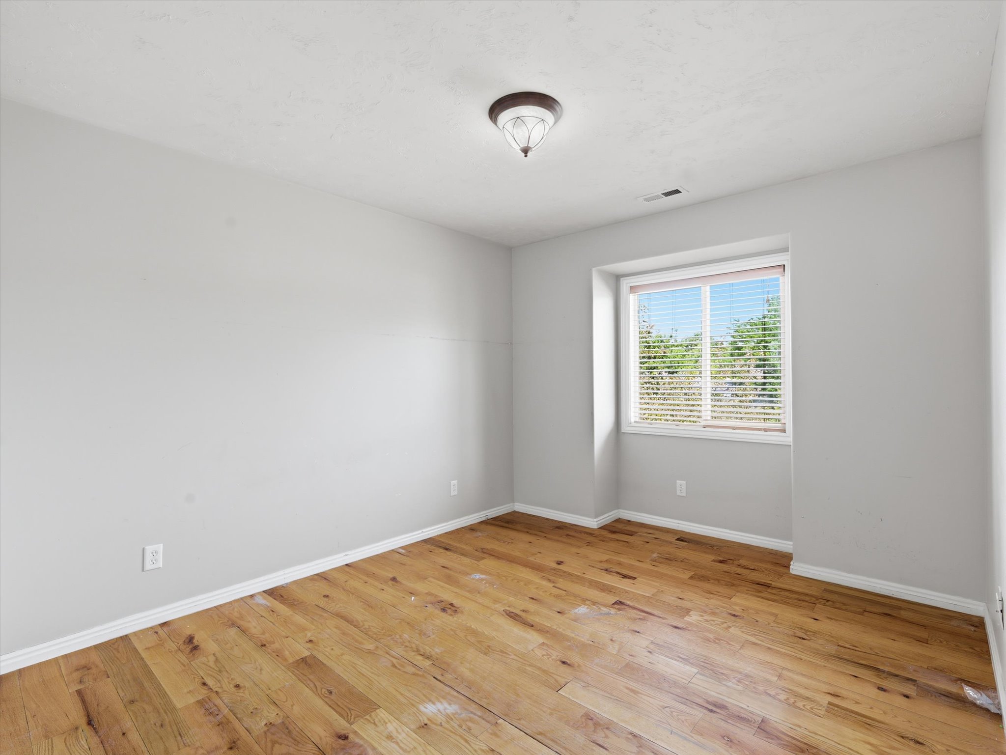 Interior space featuring wood-finish flooring, white baseboards, and light gray walls
