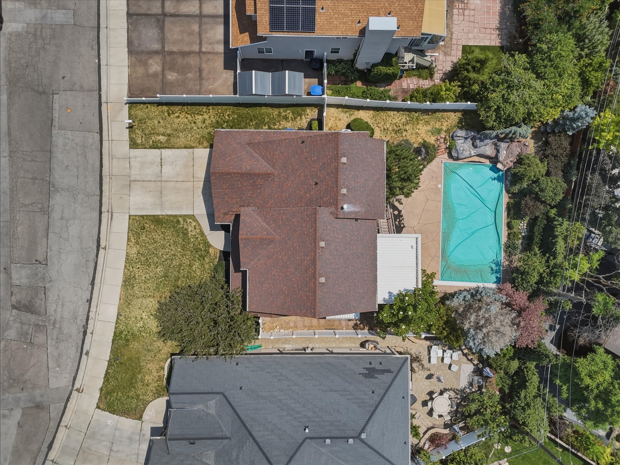 Property featuring a multi-gabled roof, an inground swimming pool with a surrounding patio, a concrete driveway, and a well-defined front yard