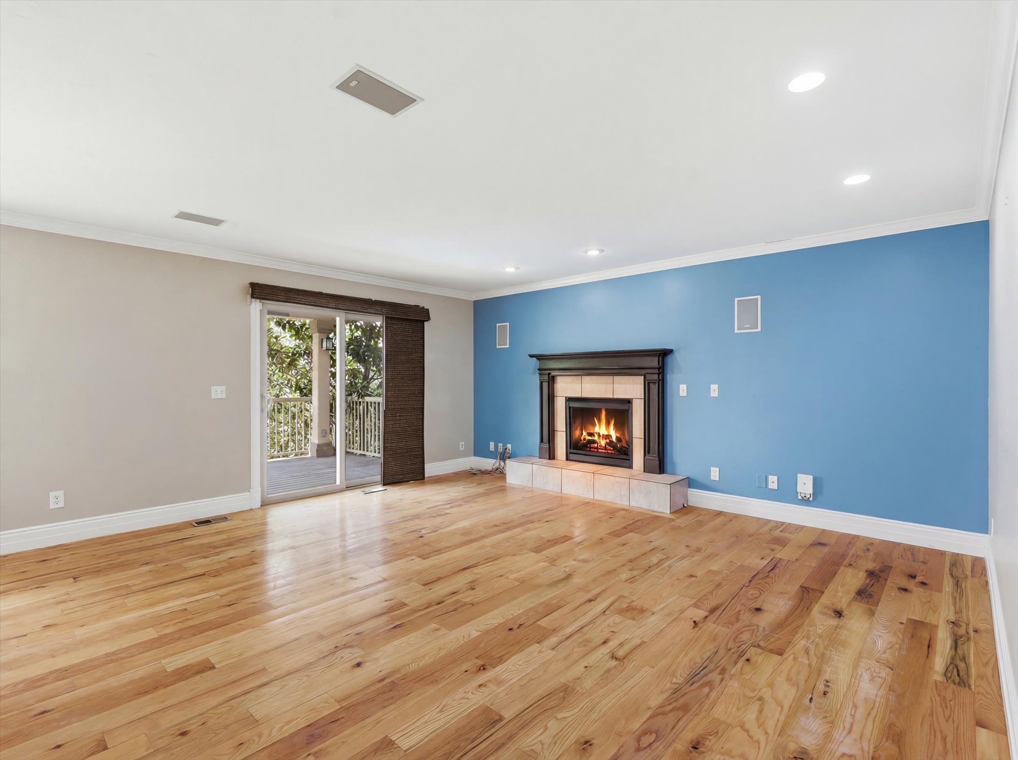 Hardwood flooring throughout featuring a built-in fireplace with tile hearth and dark wood mantle