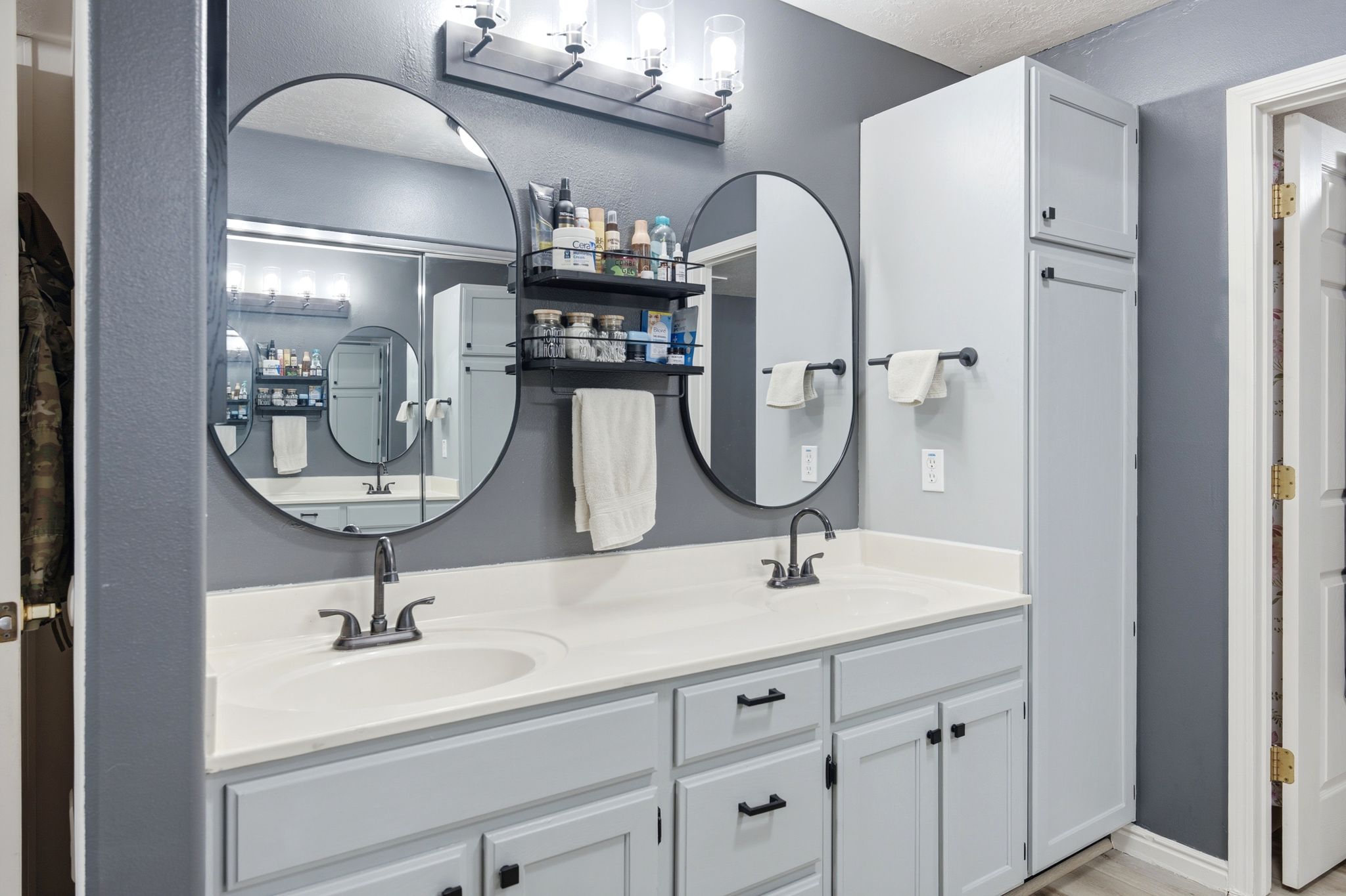 Master bath with a double vanity with light gray cabinetry and white countertops
