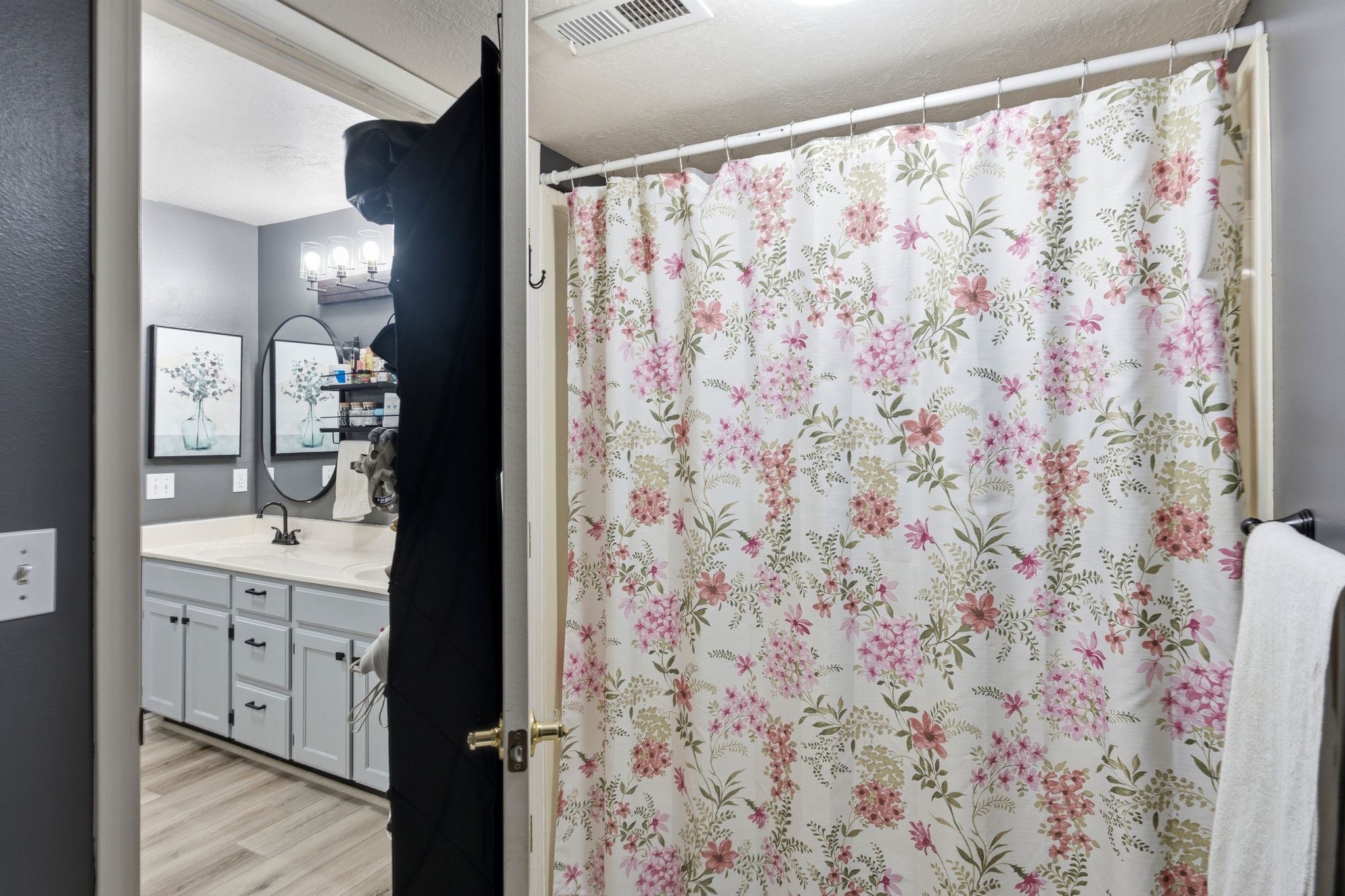 Master bathroom featuring a double vanity with light gray cabinetry, a white countertop, and dark-finish hardware