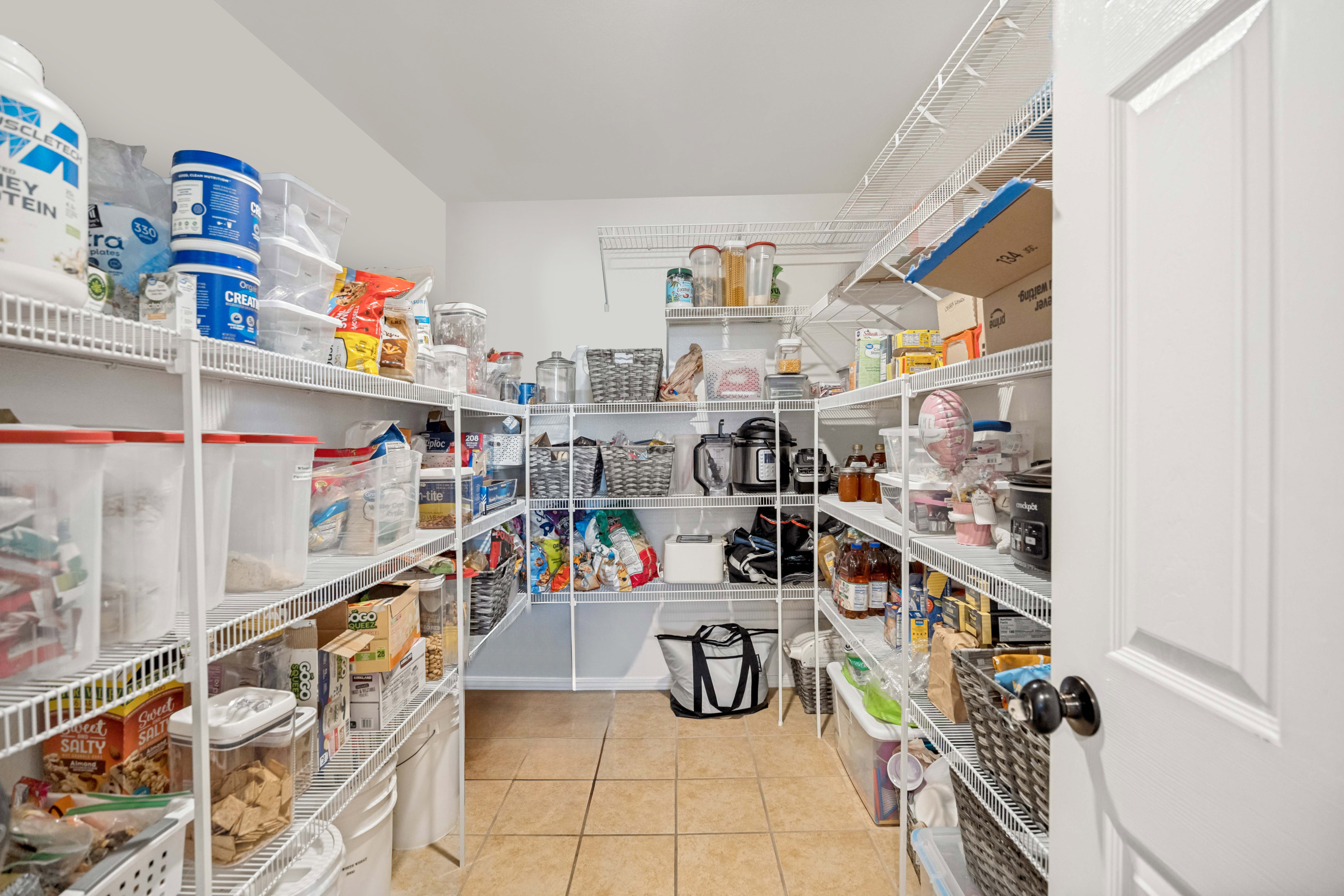Walk-in pantry featuring extensive wire shelving, neutral wall paint, and ceramic tile flooring