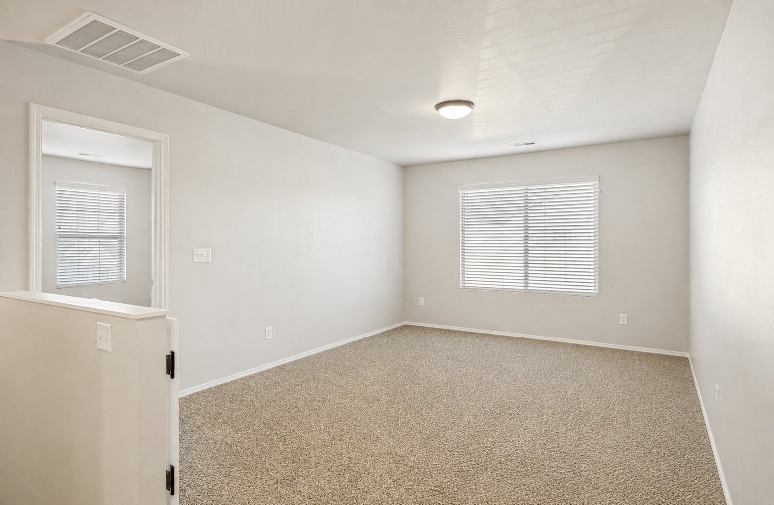 Carpeted interior space featuring neutral wall tones