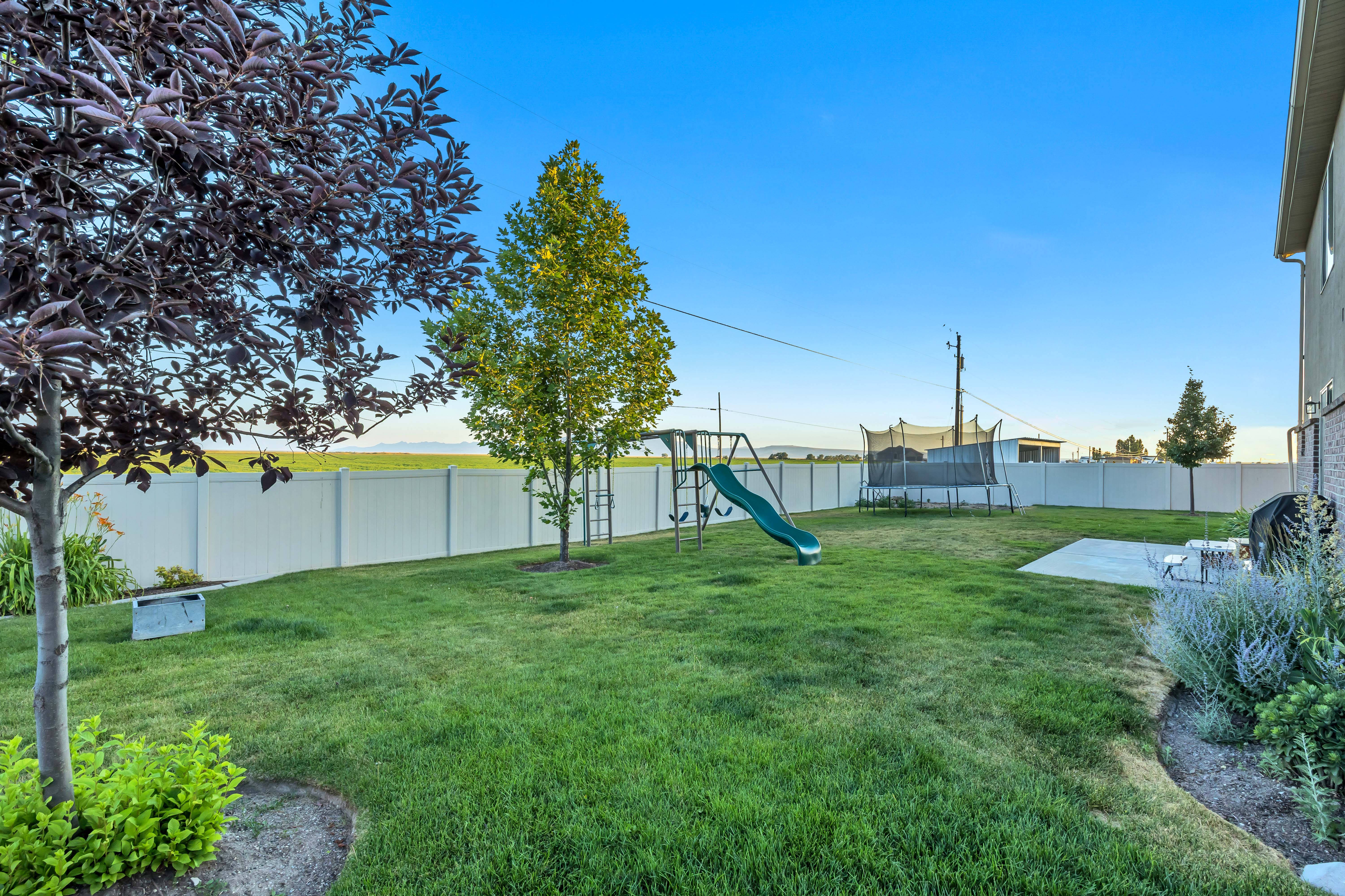 Spacious backyard featuring a manicured lawn, a concrete patio, and a privacy fence