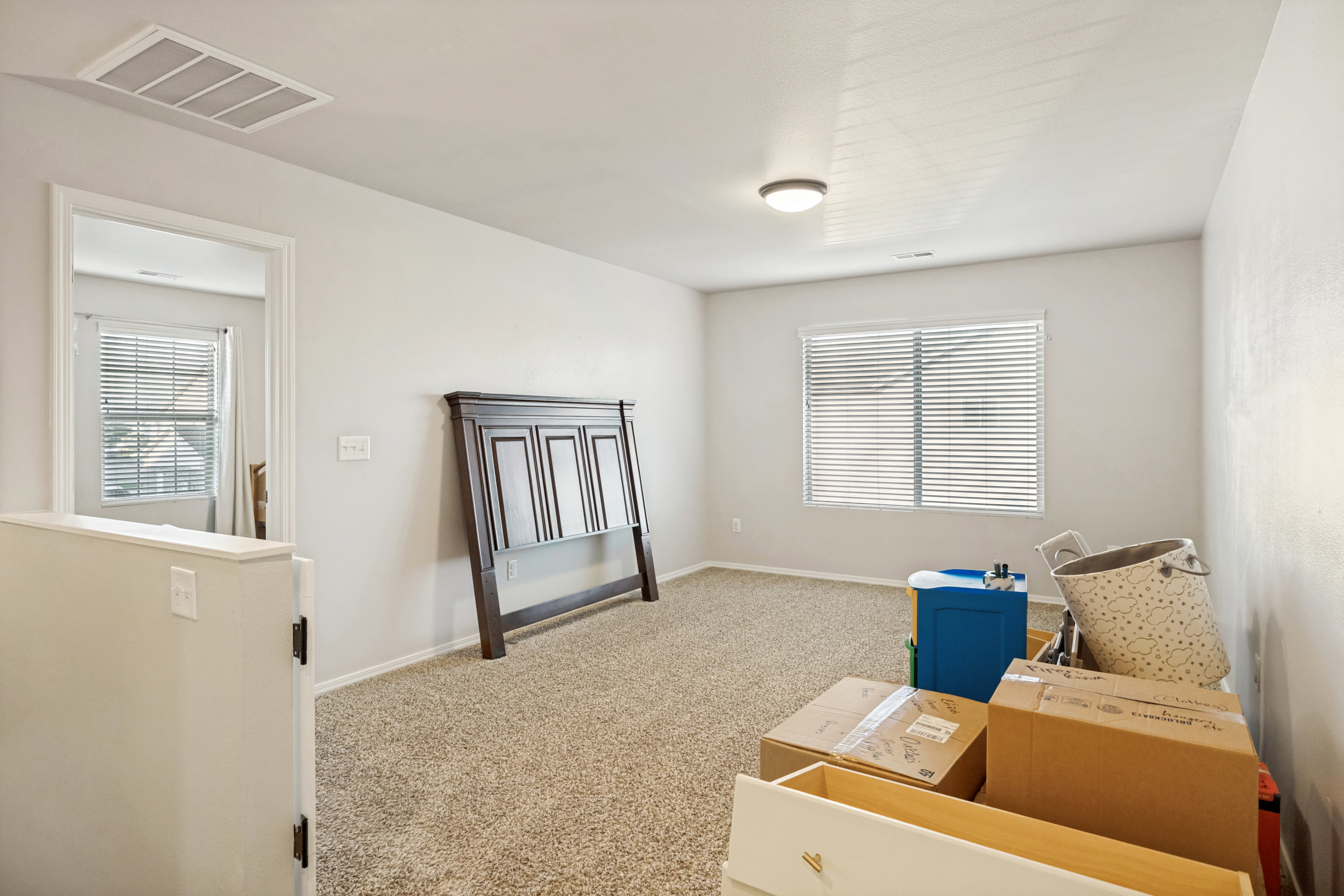 Carpeted room with a single window featuring horizontal blinds