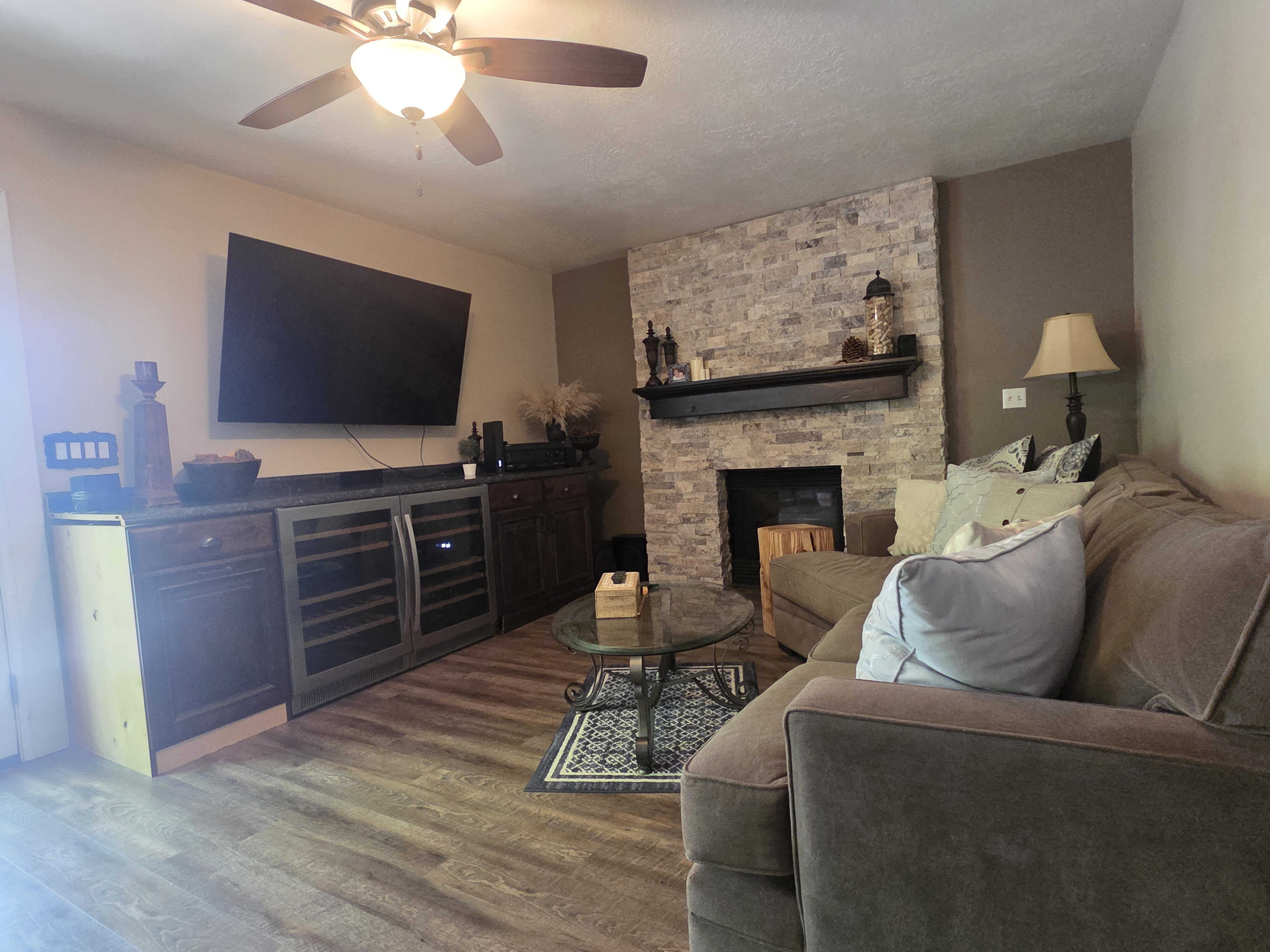 Living area featuring a stone accent wall with a fireplace and wood mantel