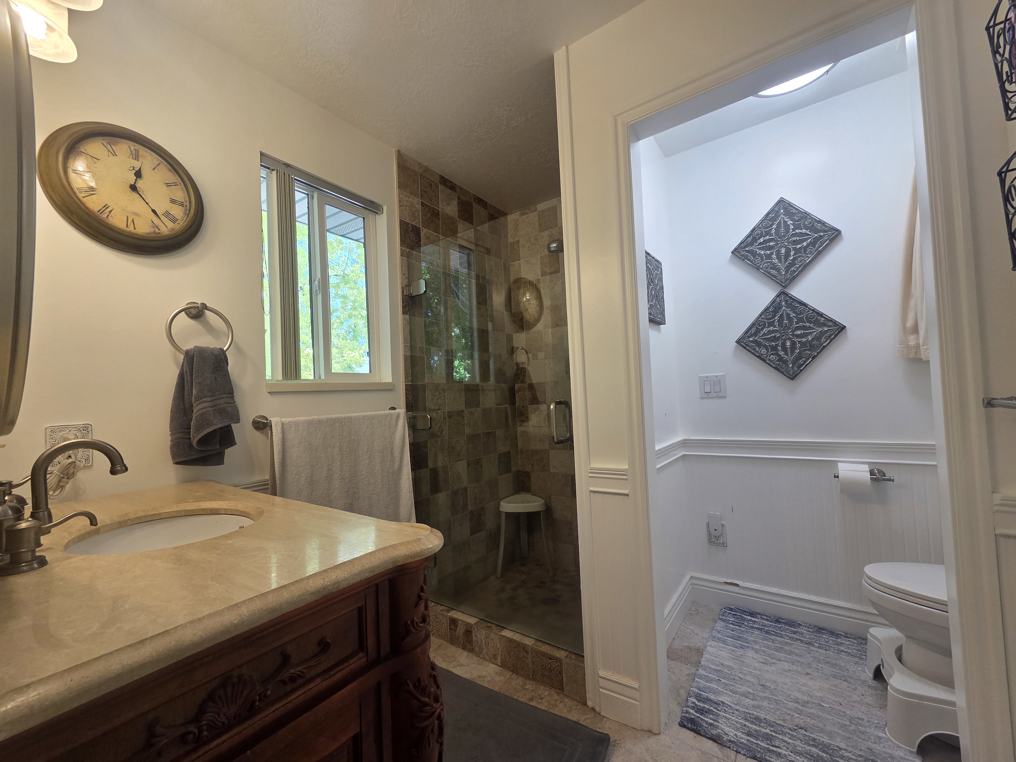 Bathroom featuring a carved wood vanity with a stone countertop and integrated sink