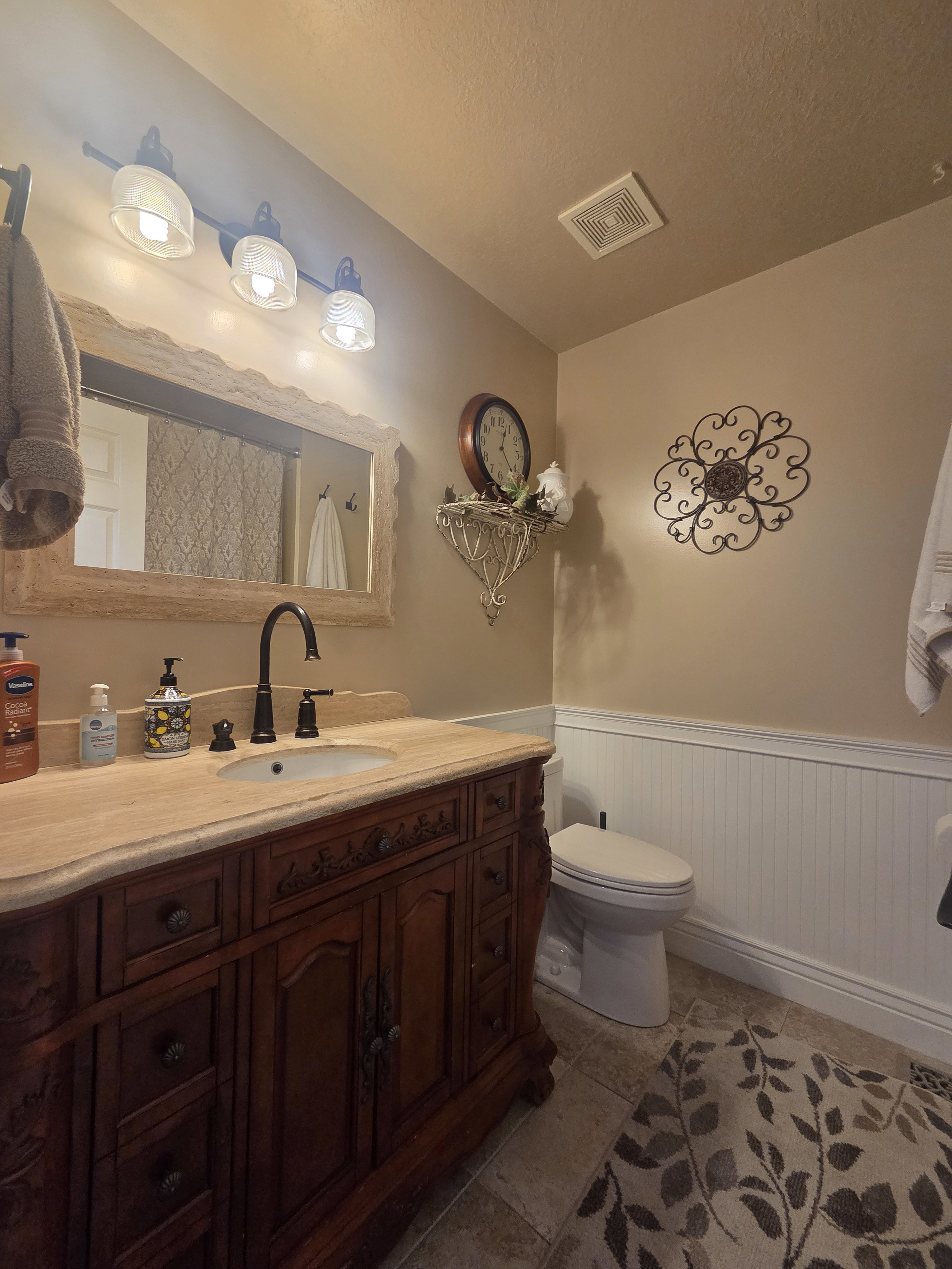 Ornate wood vanity with a solid surface countertop and undermount sink