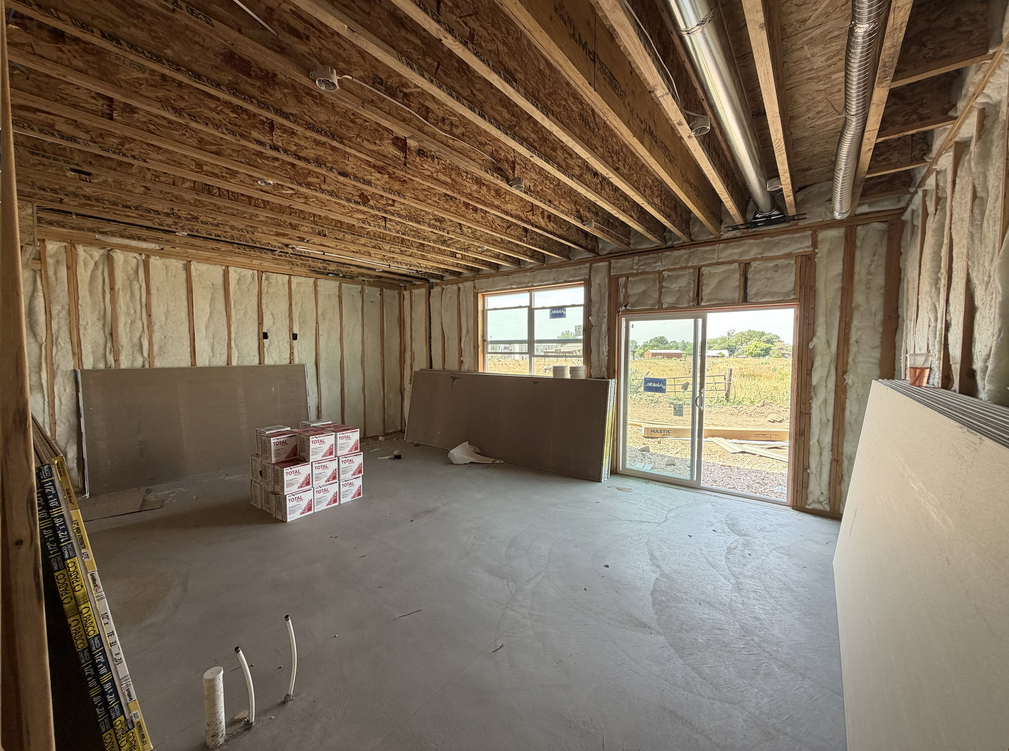 Unfinished interior space featuring exposed ceiling joists, spray foam insulation, and concrete flooring