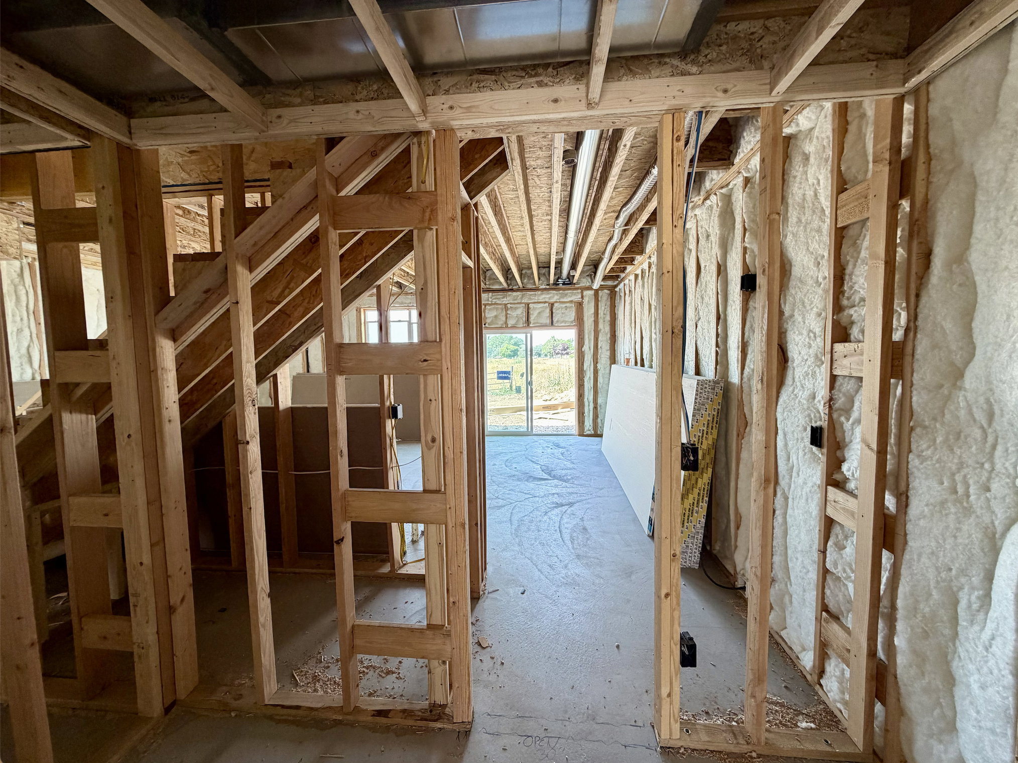 Interior framing showcasing wood studs and exposed ceiling joists