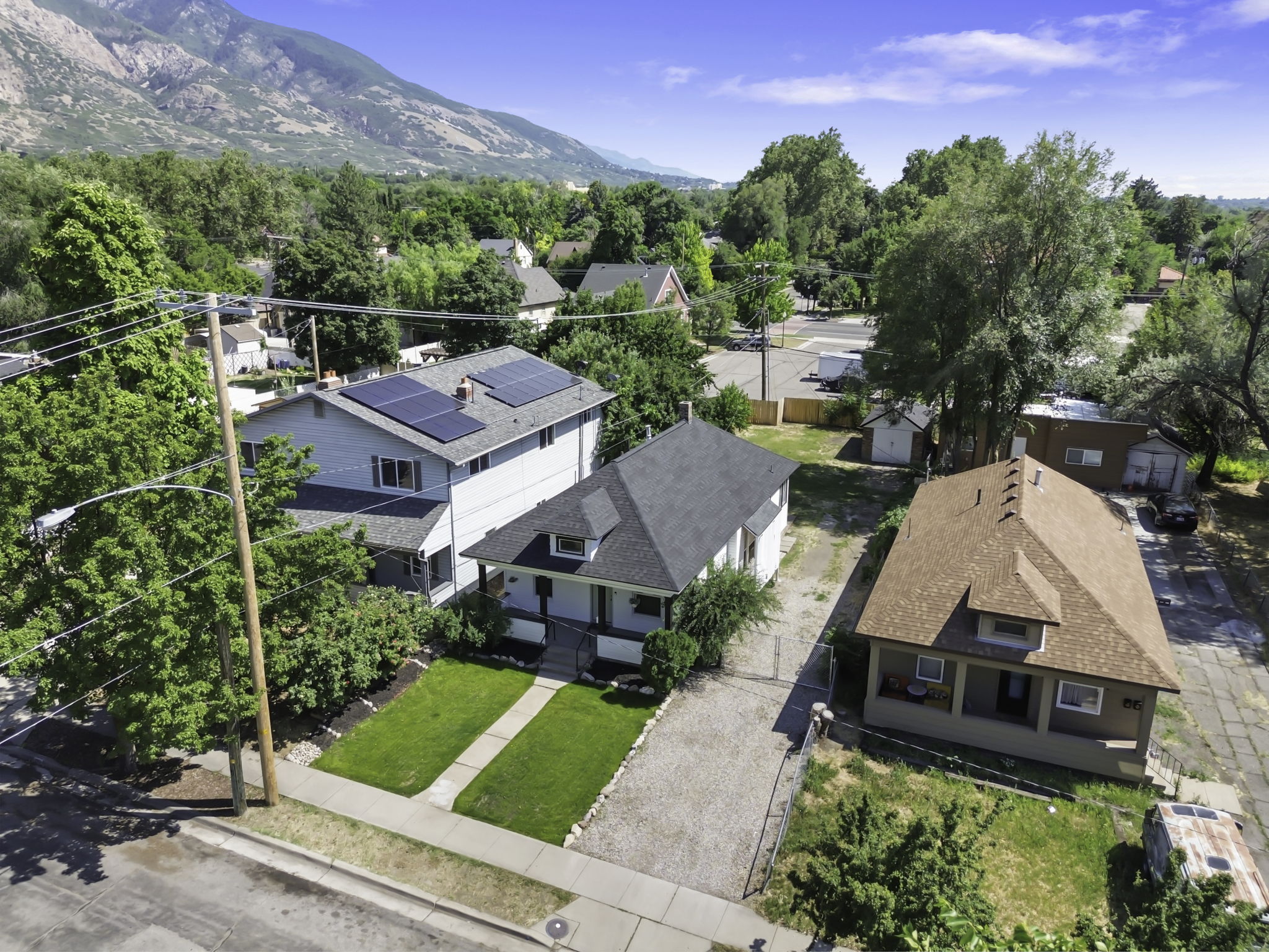 Aerial perspective showcasing a residential property with a neatly maintained front lawn and a paved driveway