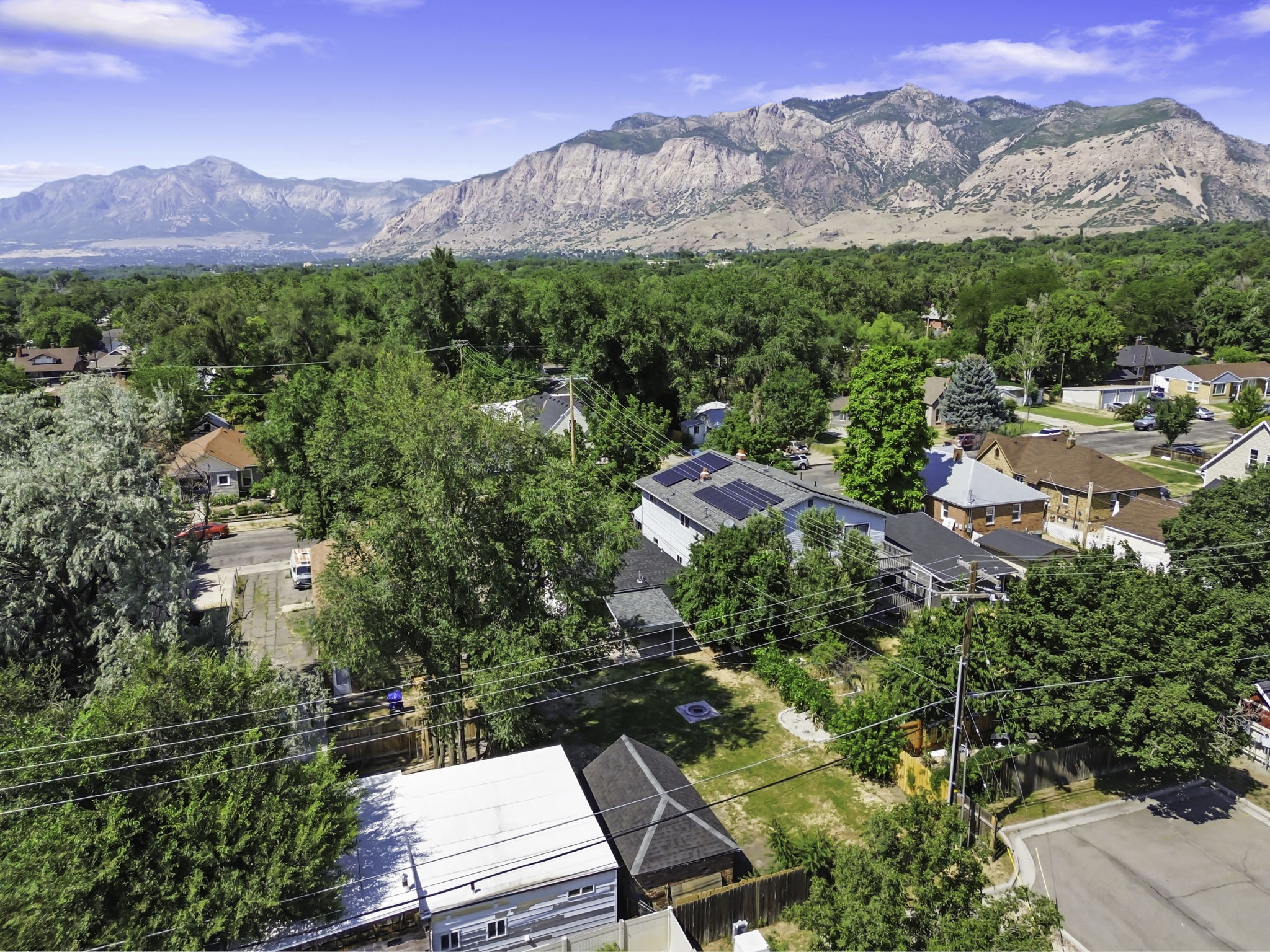 Expansive mountain backdrop framing a residential neighborhood with mature trees
