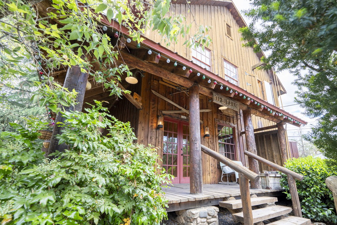 Wood-sided exterior featuring a covered porch with log supports and railings