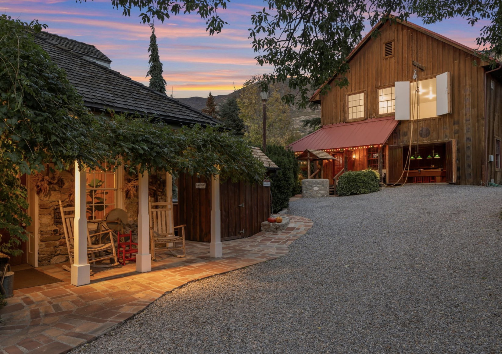 Stone-clad structure with vine-covered porch and brick pathway