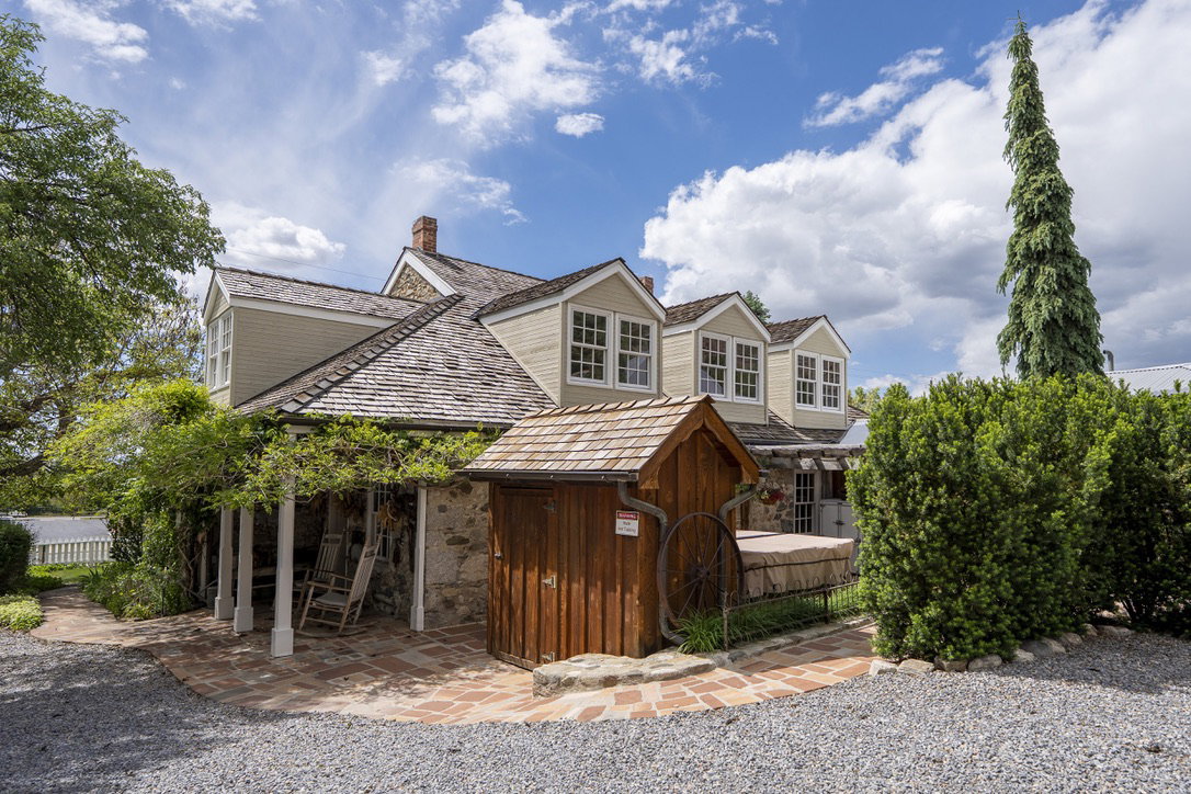 South Side Stone and siding exterior with multiple dormer windows, a wood shake roof, and a brick patio