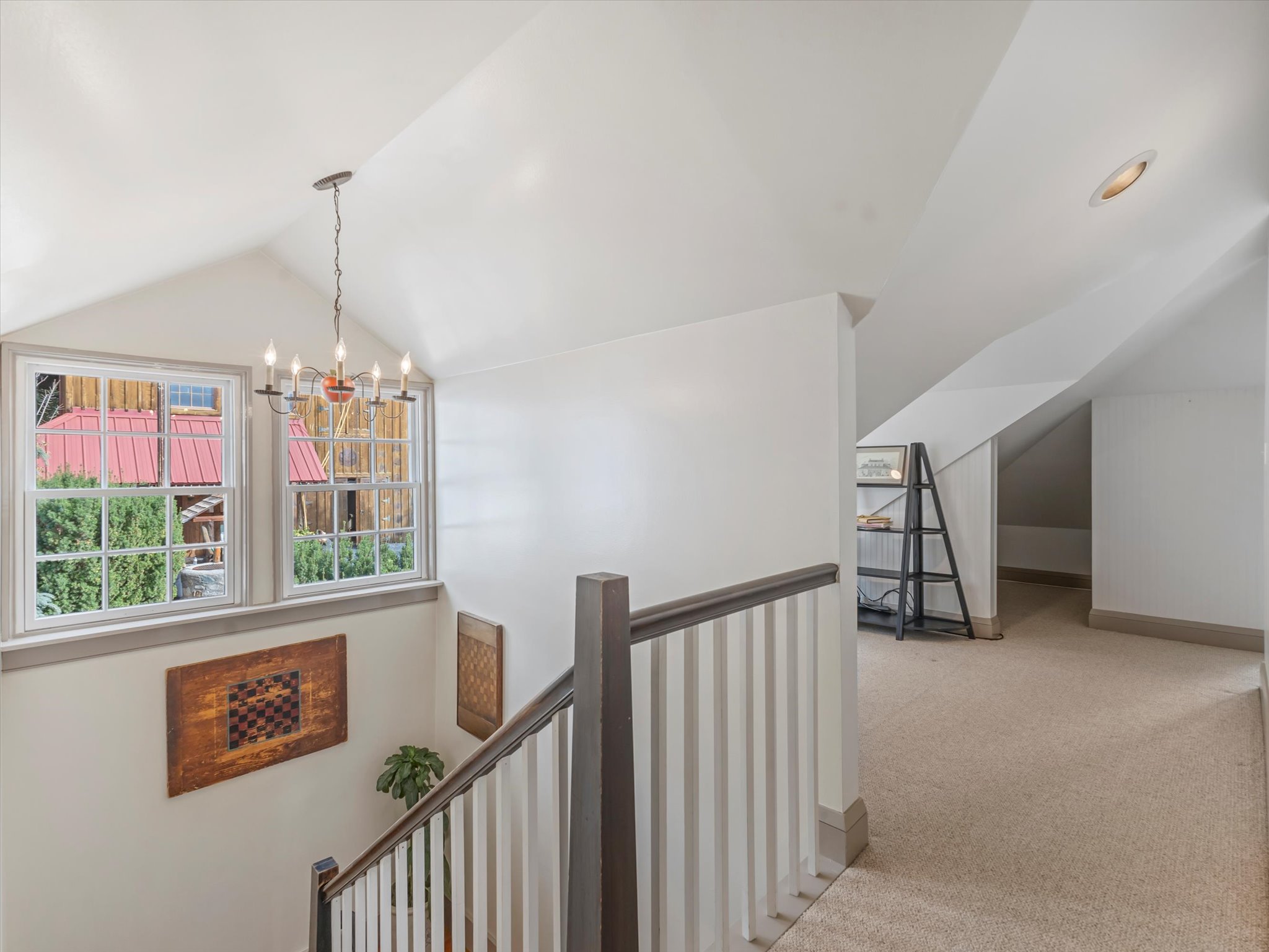 Carpeted upper hallway with vaulted ceilings and a recessed light fixture