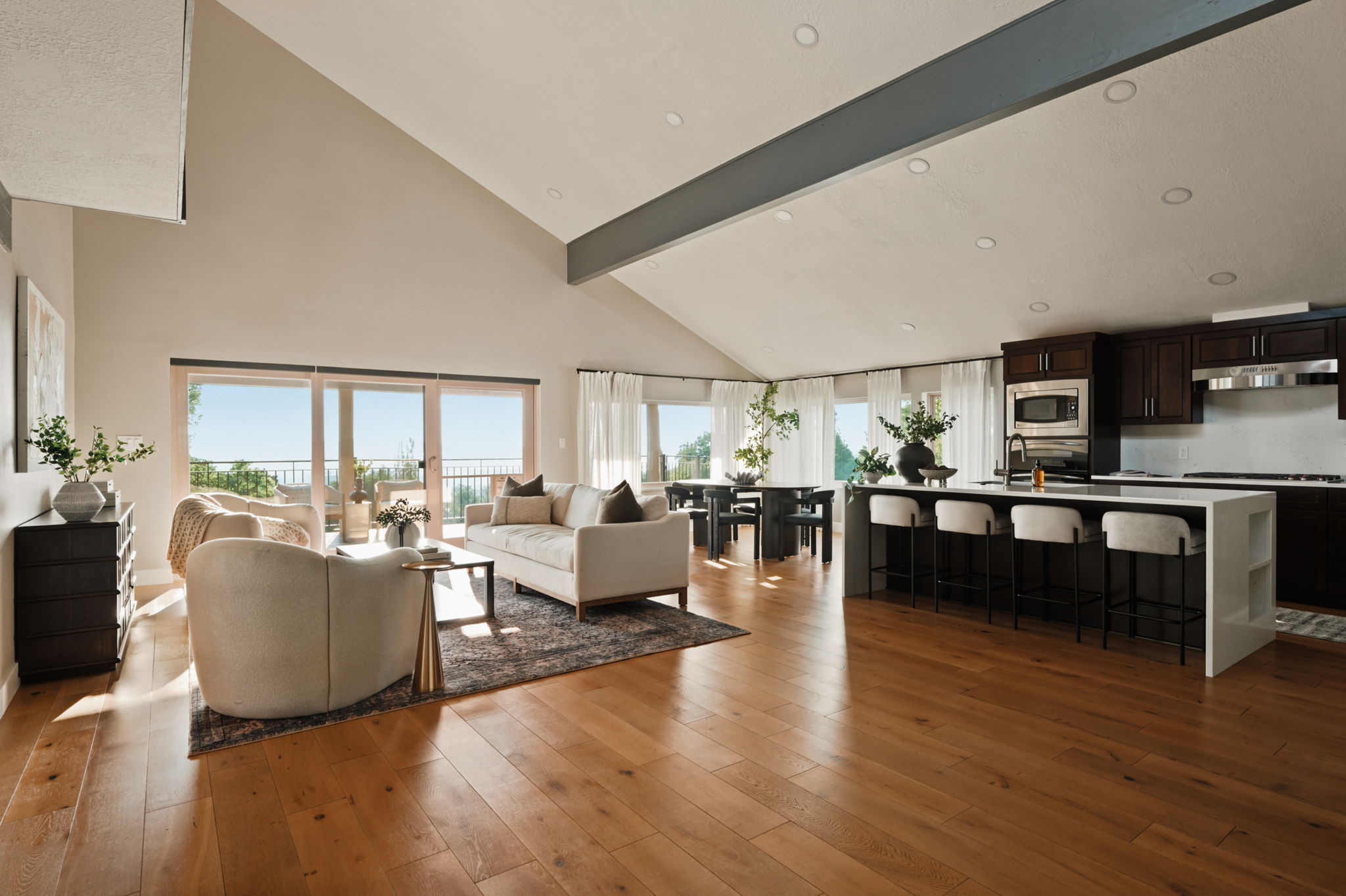 Open-concept living area with vaulted ceilings and wood-finish flooring
