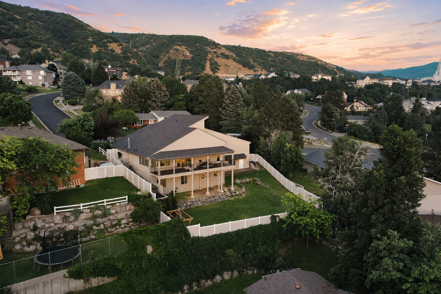 Two-story residence featuring a covered upper-level balcony and a lower-level patio with columnar supports