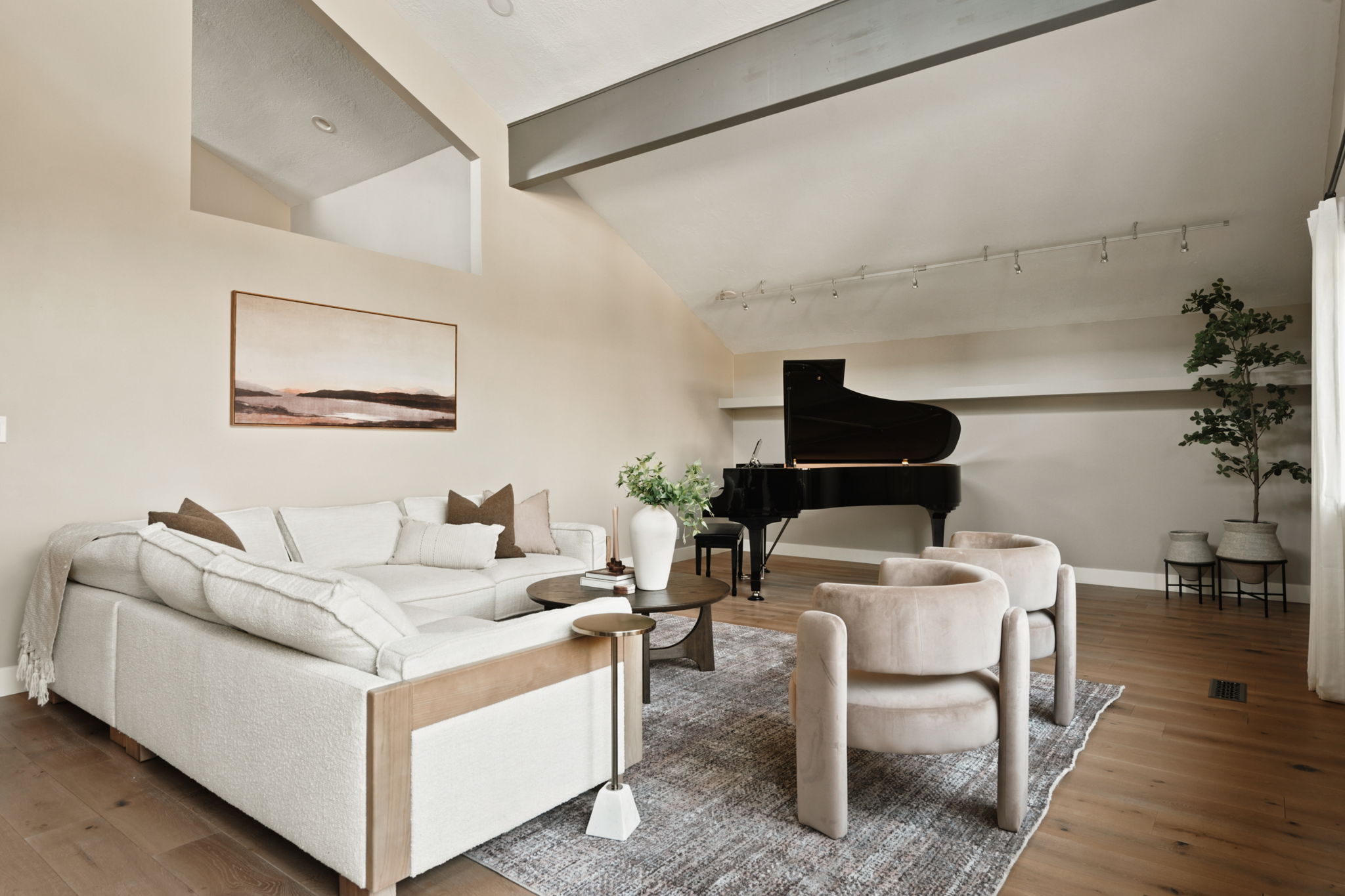 Vaulted ceiling with exposed beam, wood-finish flooring, recessed lighting, and track lighting fixtures
