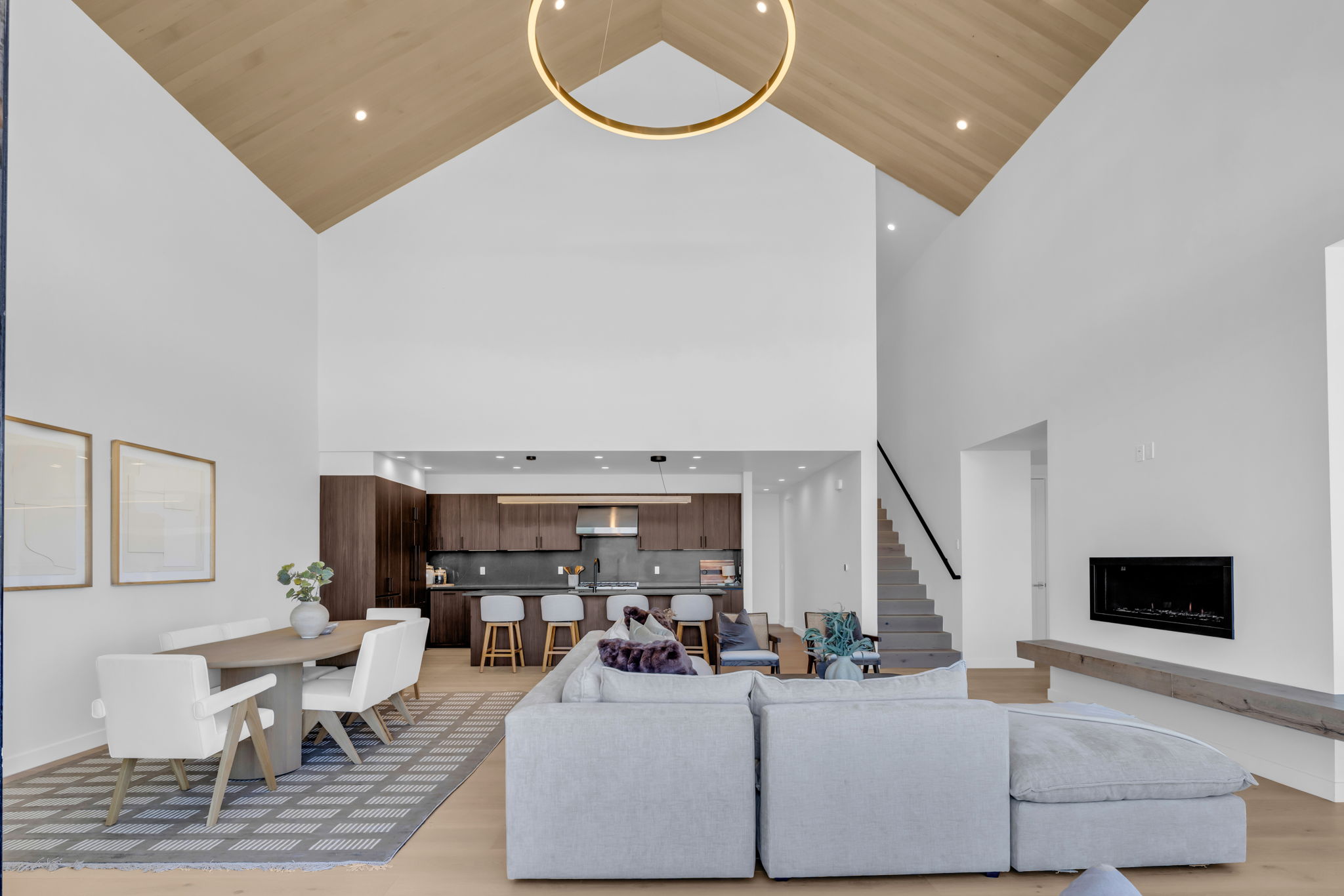 Vaulted ceilings with wood-finish paneling and an overhead ring light fixture