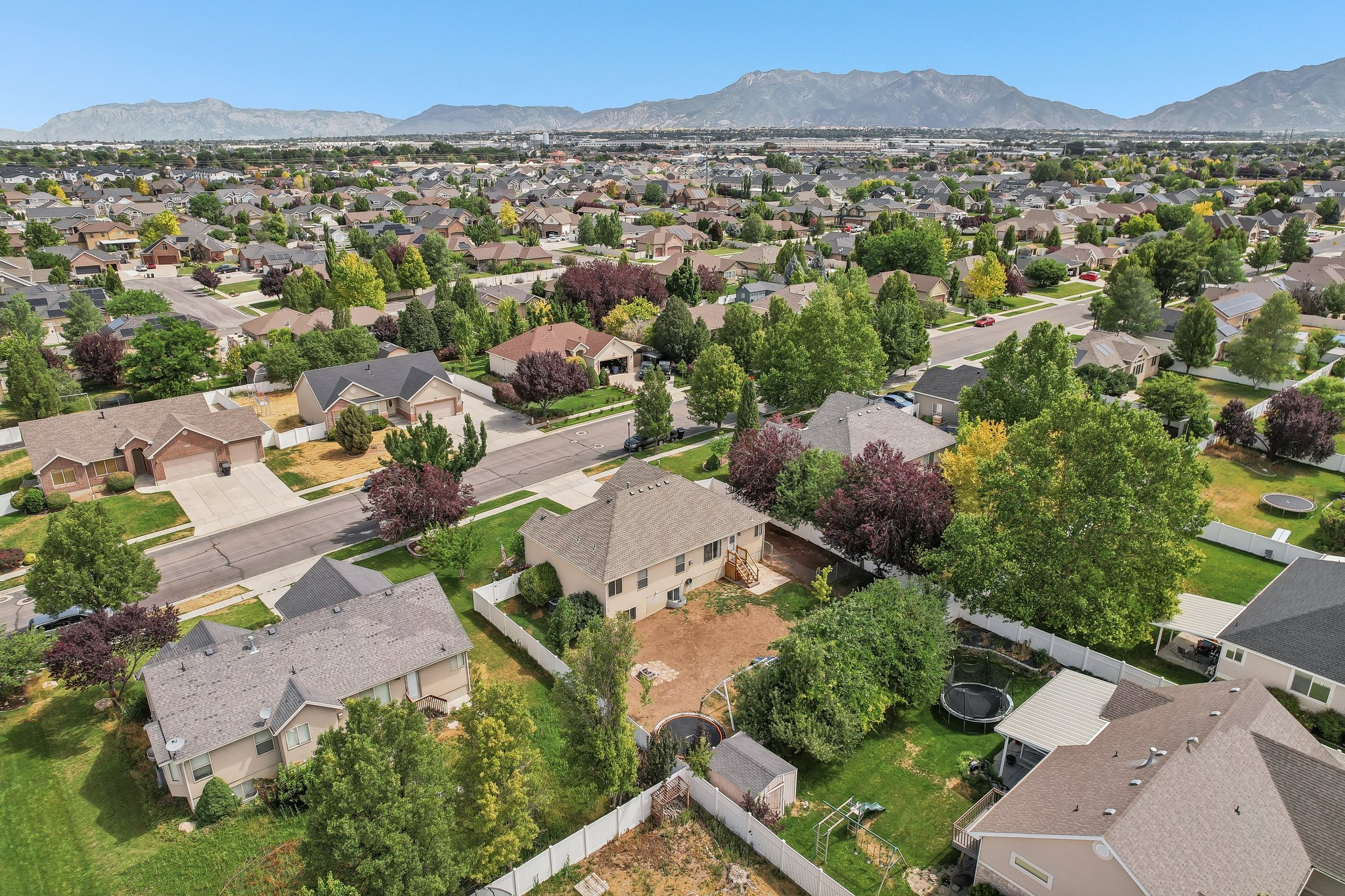 Expansive aerial view showcasing a residential area with varied housing styles and mature landscaping