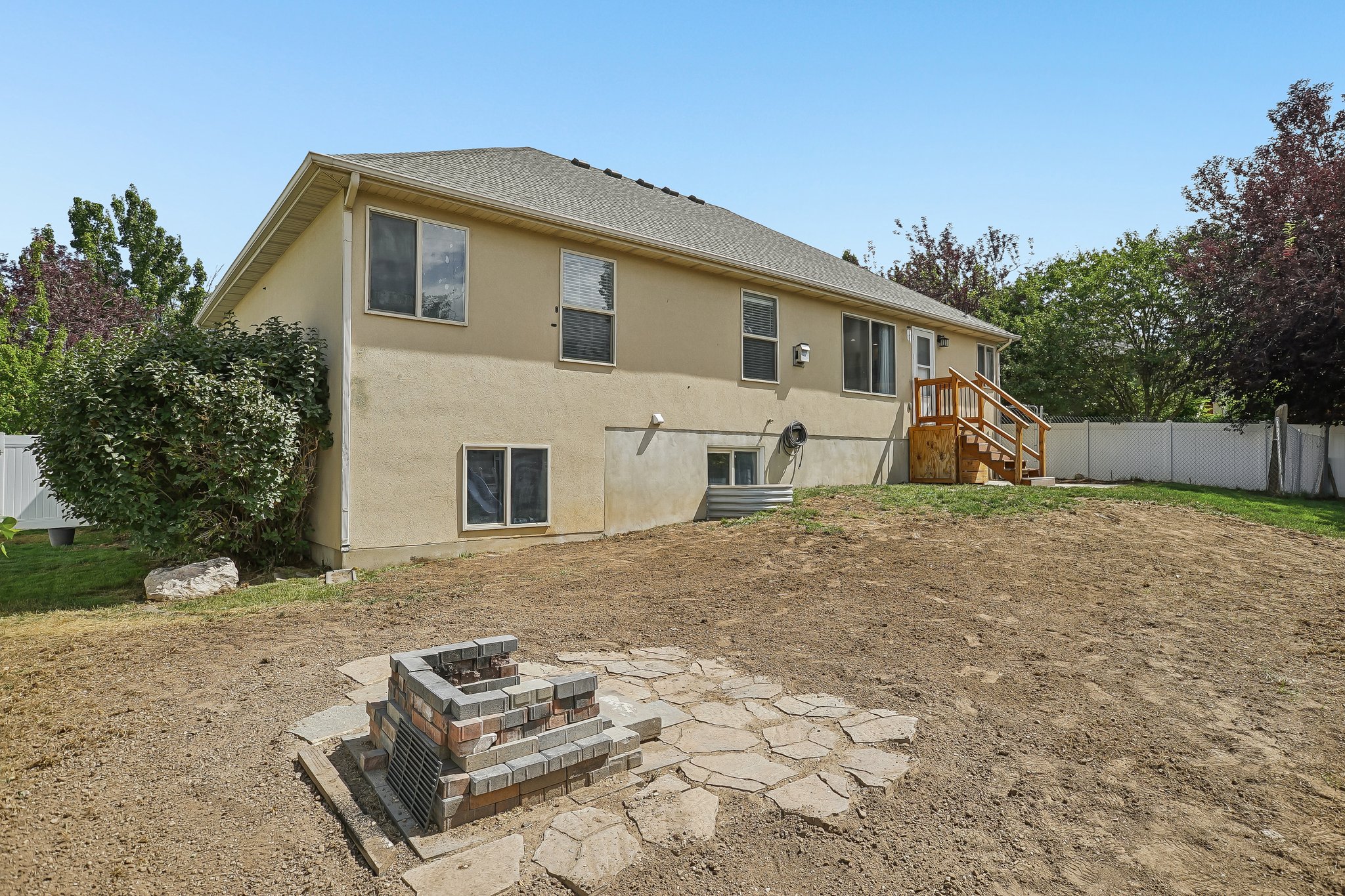 Rear exterior featuring a stone paver fire pit area