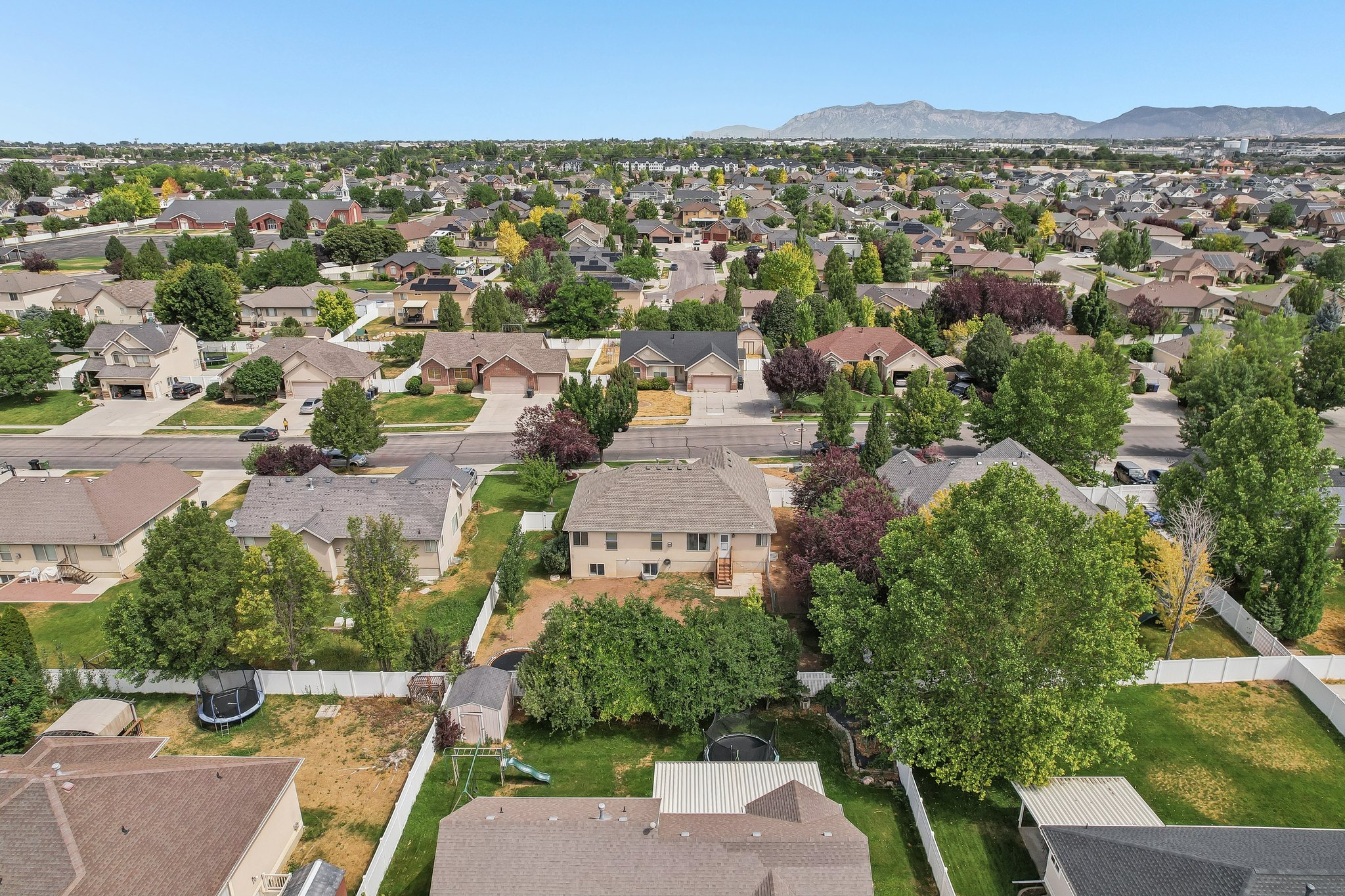 Expansive residential development featuring a diverse range of single-family homes with mature landscaping and mountain scenery