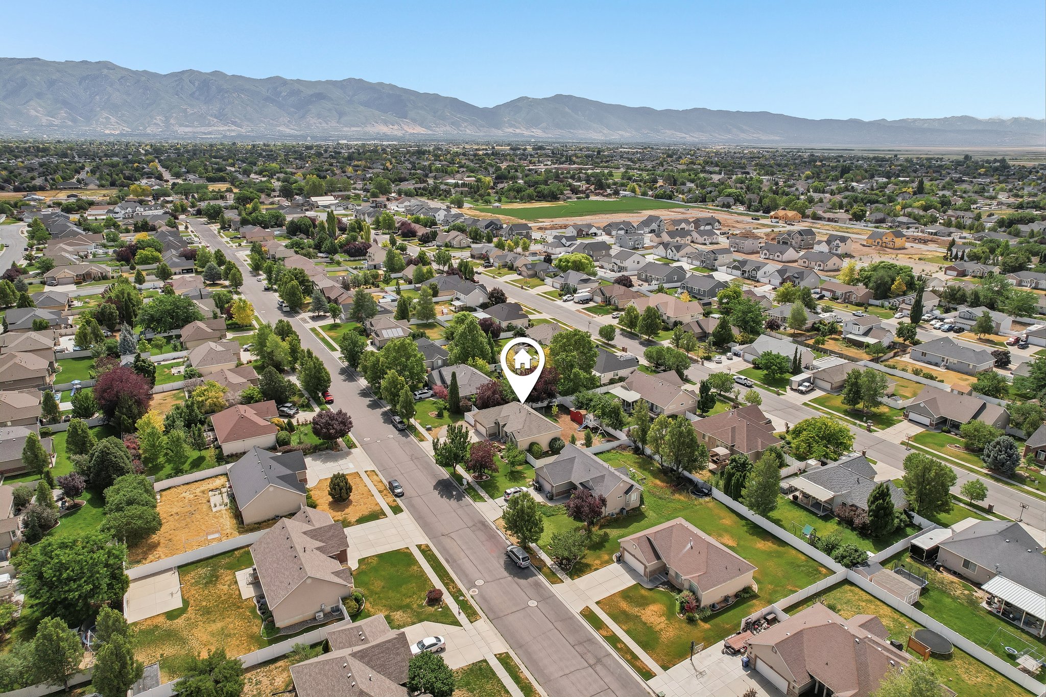 Expansive aerial perspective showcasing a residential neighborhood with a backdrop of distant mountains