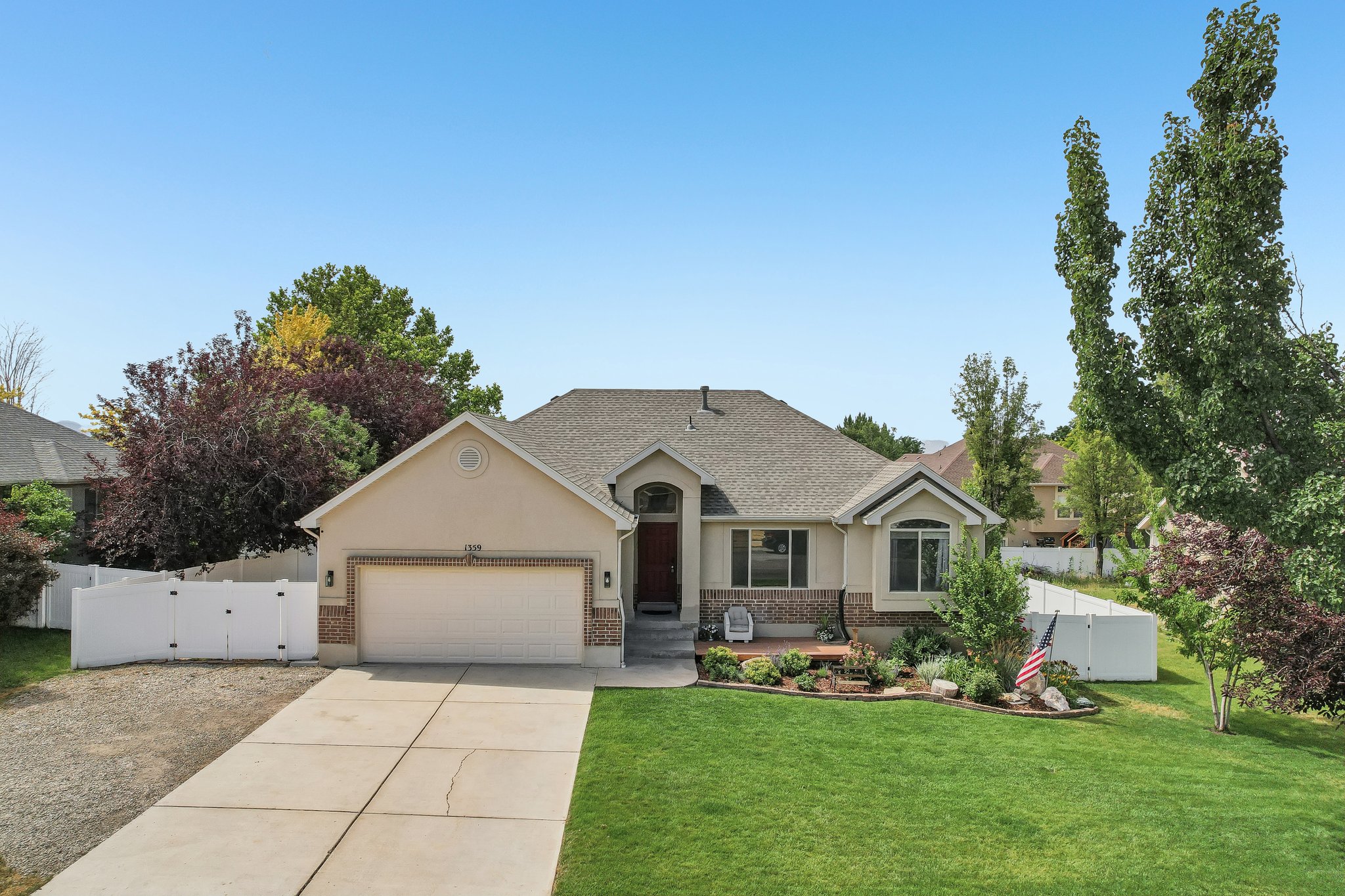 Single-story residence featuring a two-car garage, partial brick facade, and a covered entry