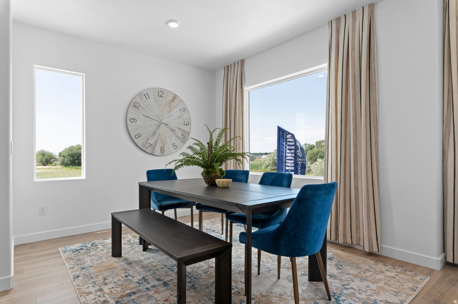 Dining area featuring wood-finish flooring, a rectangular window, a large picture window, recessed lighting, and white baseboards