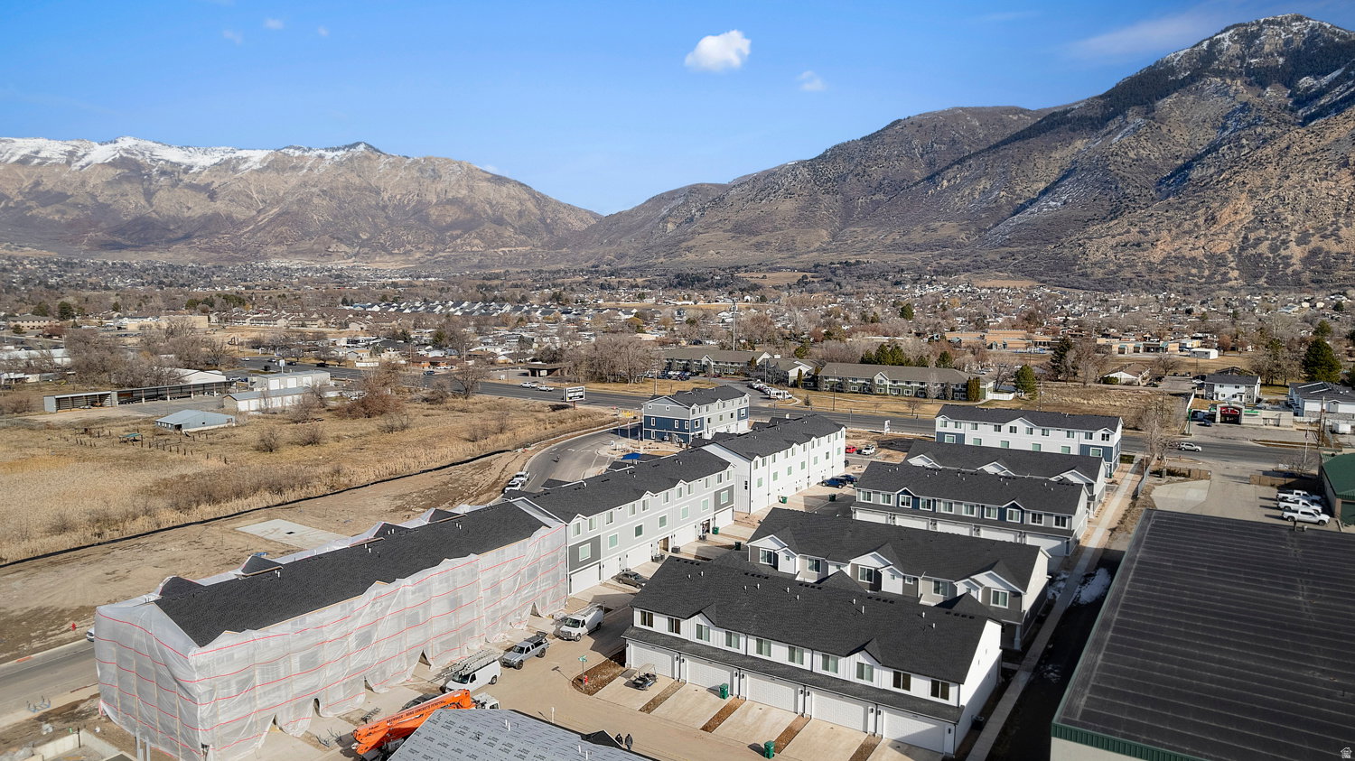 Newly constructed townhome community featuring varied architectural styles and dark shingle roofing