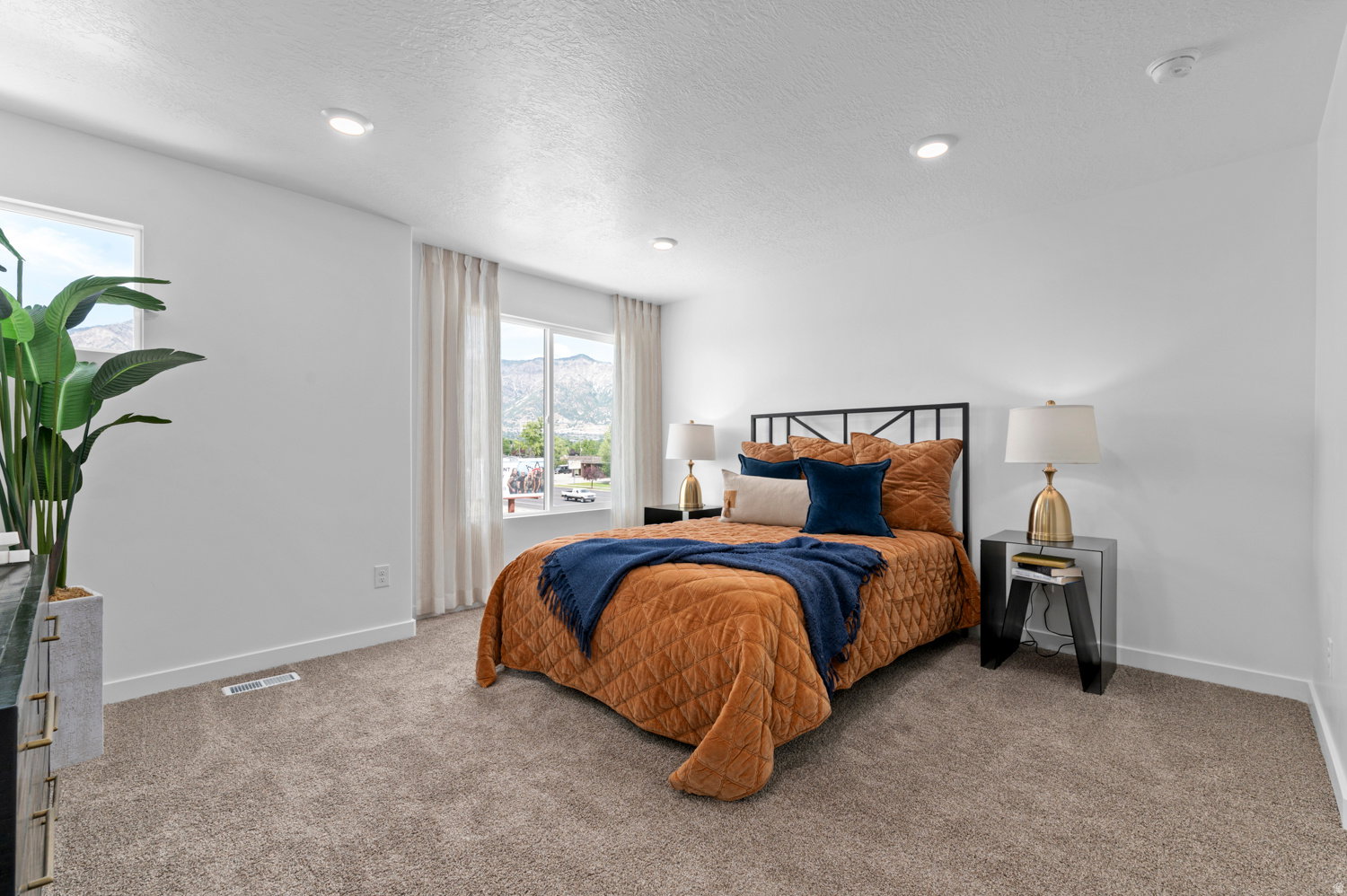 Carpeted bedroom with recessed lighting and a window offering a mountain backdrop