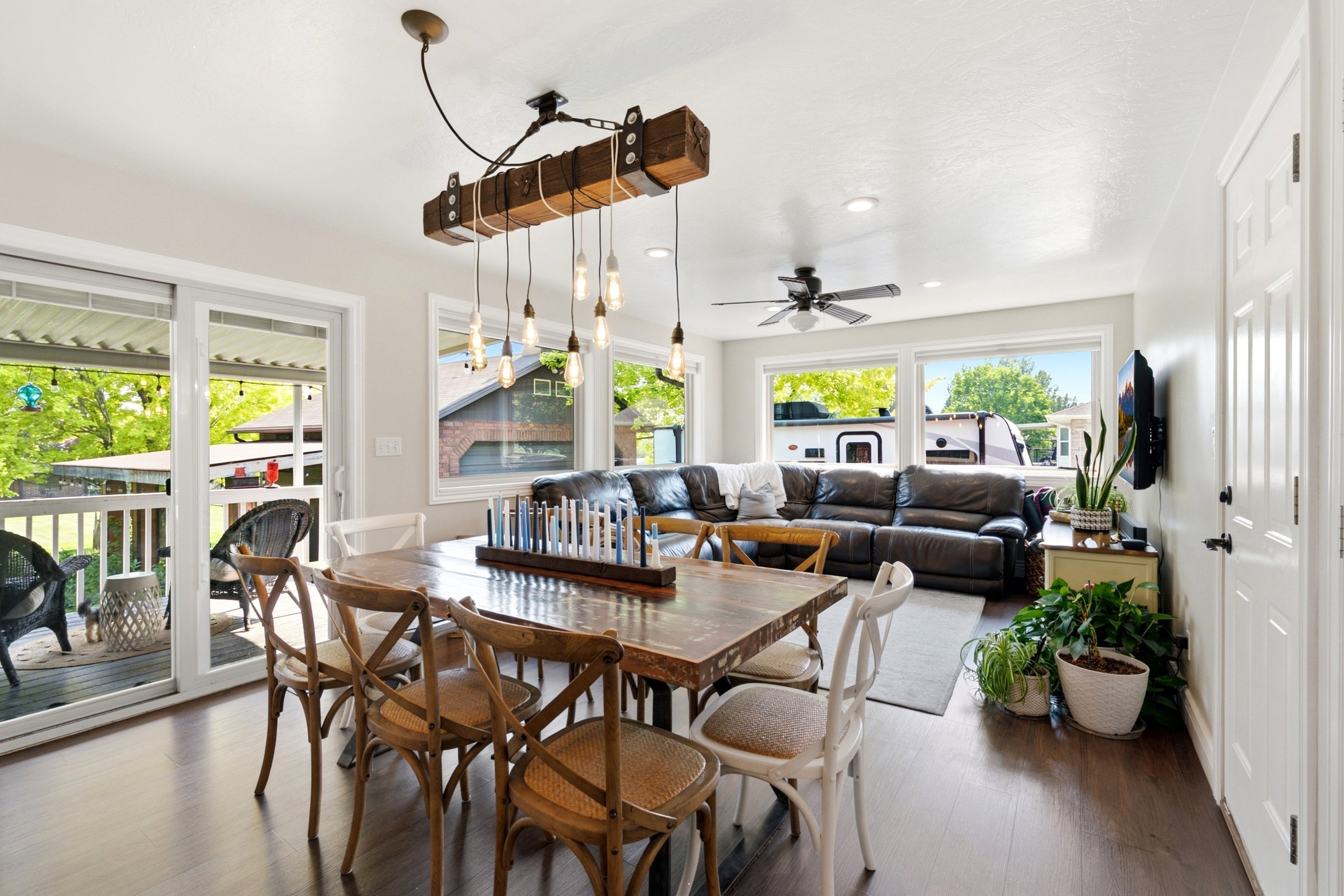 Open-concept living area featuring wood-finish flooring, a contemporary chandelier, recessed lighting, and a ceiling fan