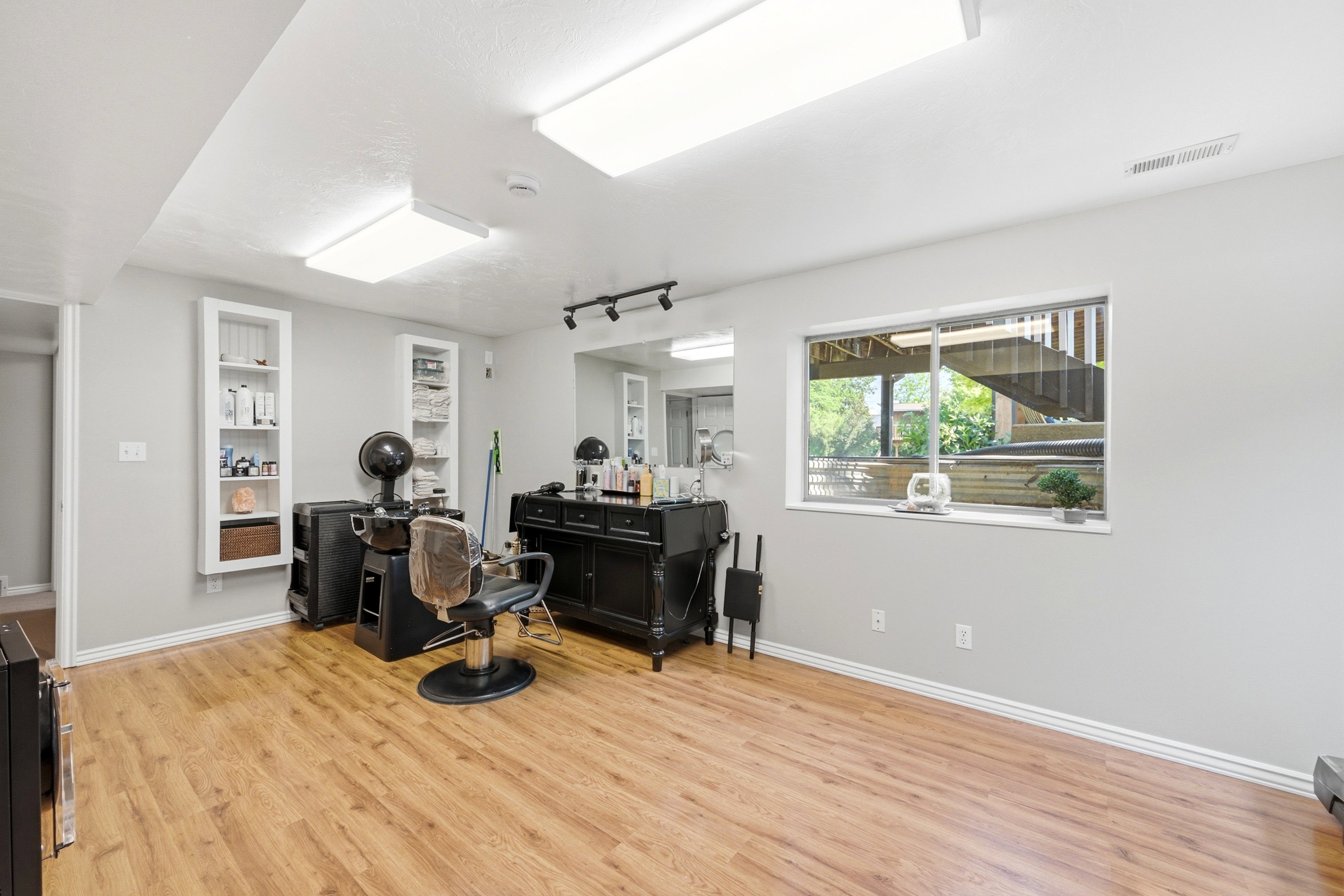 Spacious room with wood-finish flooring and ample overhead lighting