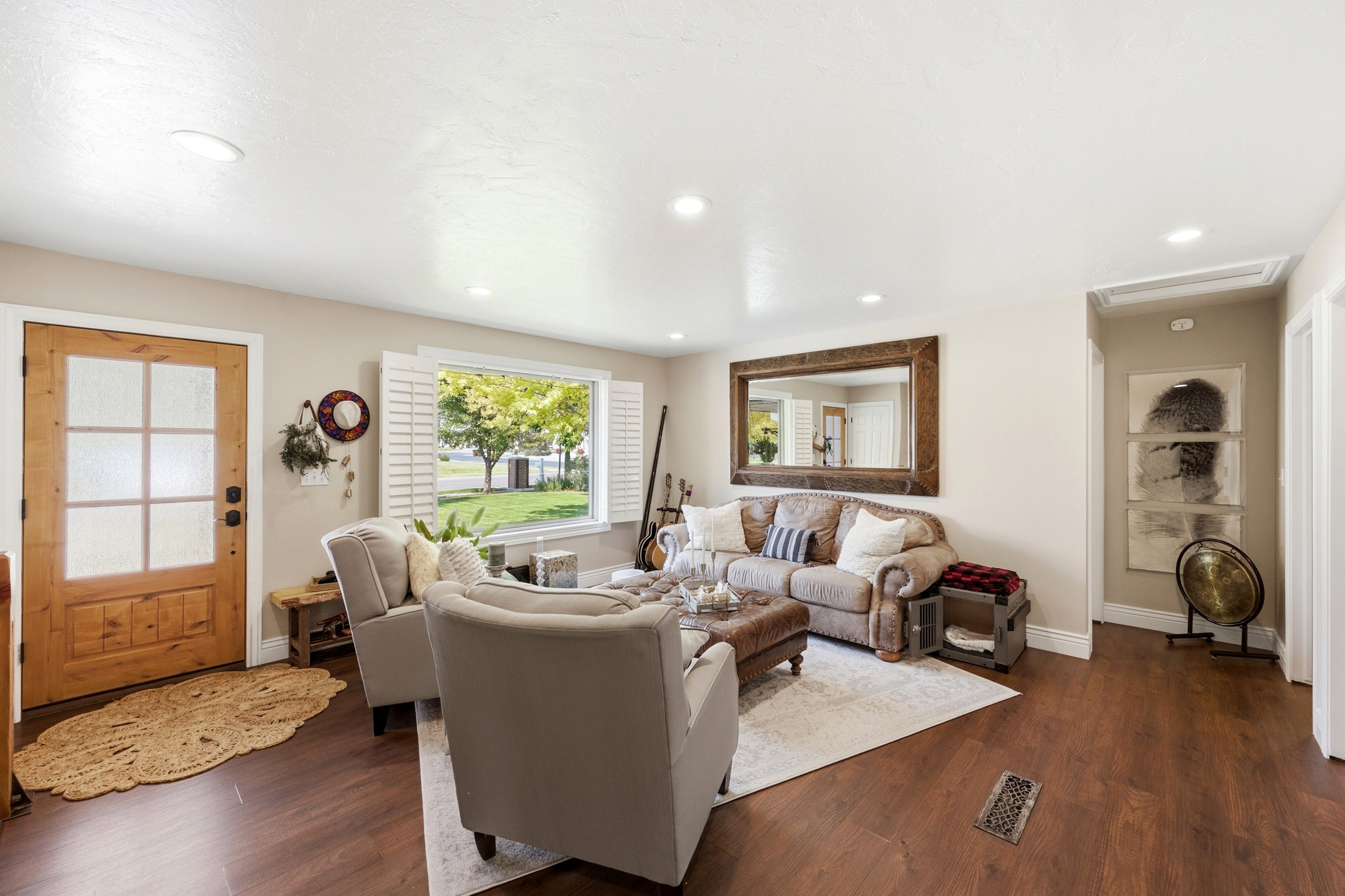 Living area featuring wood-finish flooring, recessed lighting, and a front entry door with privacy glass